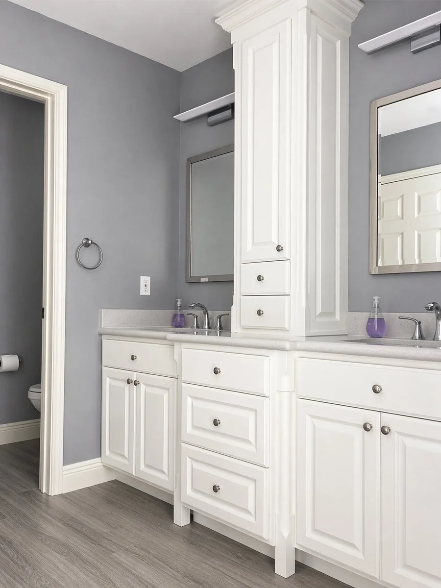 custom built bathroom vanity with column detail built into side panels and cabinet face. Vanity tower with crown detail. Soft-close dovetailed drawers with custom made raised panel drawer fronts and doors. Sprayed with white waterborne lacquer
