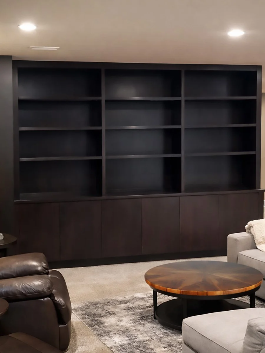 Custom shelving unit to house turntable and vinyl record collection. Custom stain and lacquer. Built-in scribed to left wall and ceiling with a finished panel on right end. Full overlay slab doors on lower cabinet.