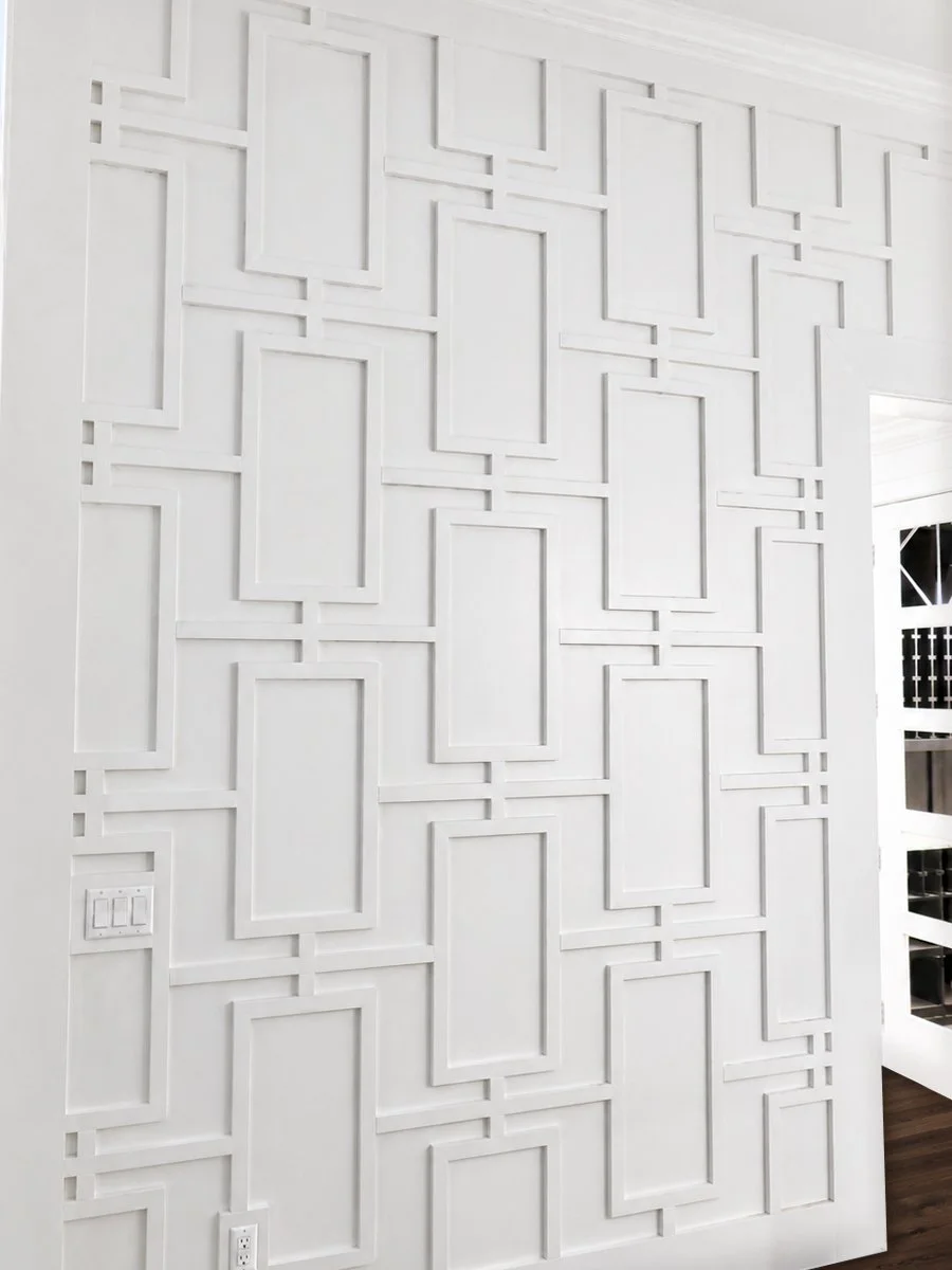 Custom focal wall. Entry wall to residence. Foyer wall with grided panels tied together with one by two trim pieces and into case door opening. Custom wall treatment paneling. 