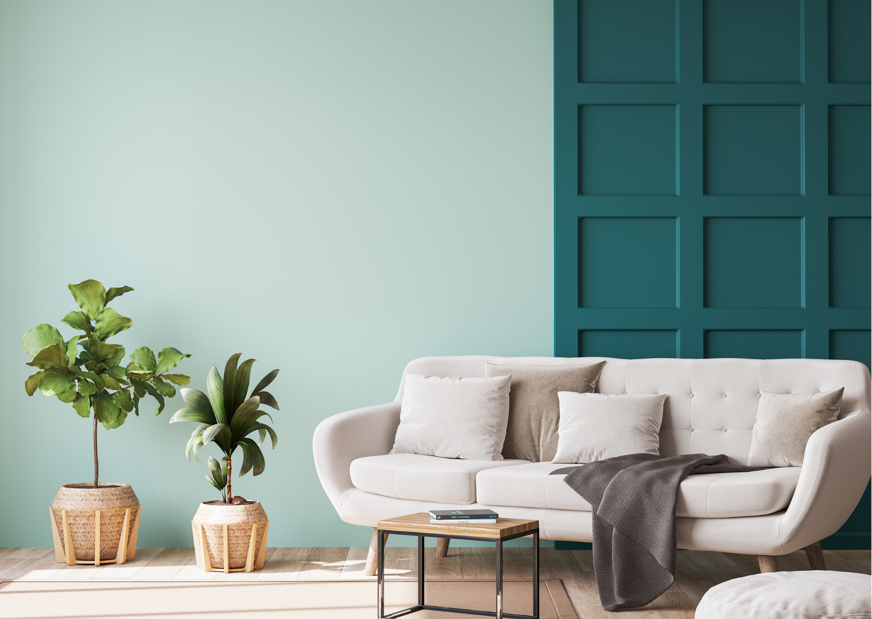 Living room with a white sofa, beige and white pillows, a dark gray throw blanket, a small wooden coffee table with a book, two potted plants in woven baskets, and a teal accent wall with a panel design.