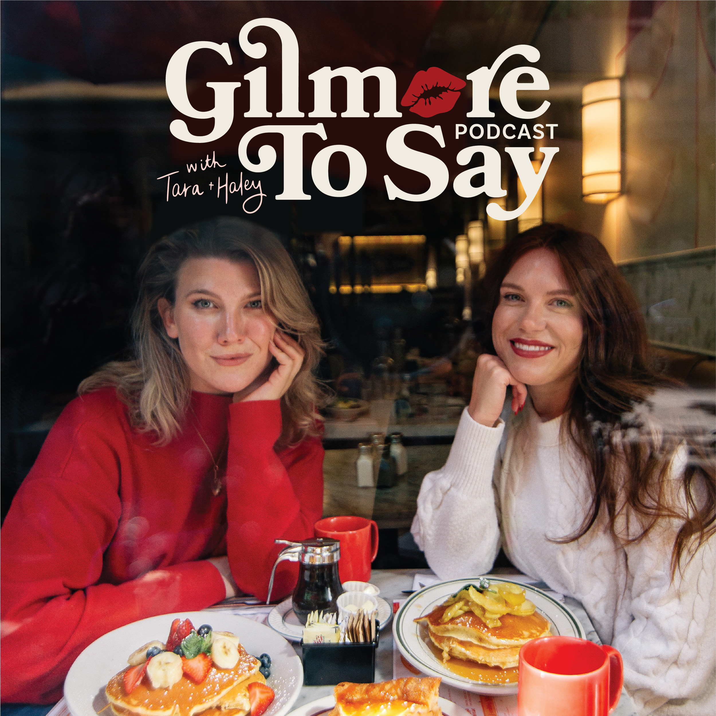Two women sitting at a table in a restaurant with breakfast food, smiling at the camera, with podcast branding 'Gimore To Say with Tara + Haley' and a red lipstick mark.