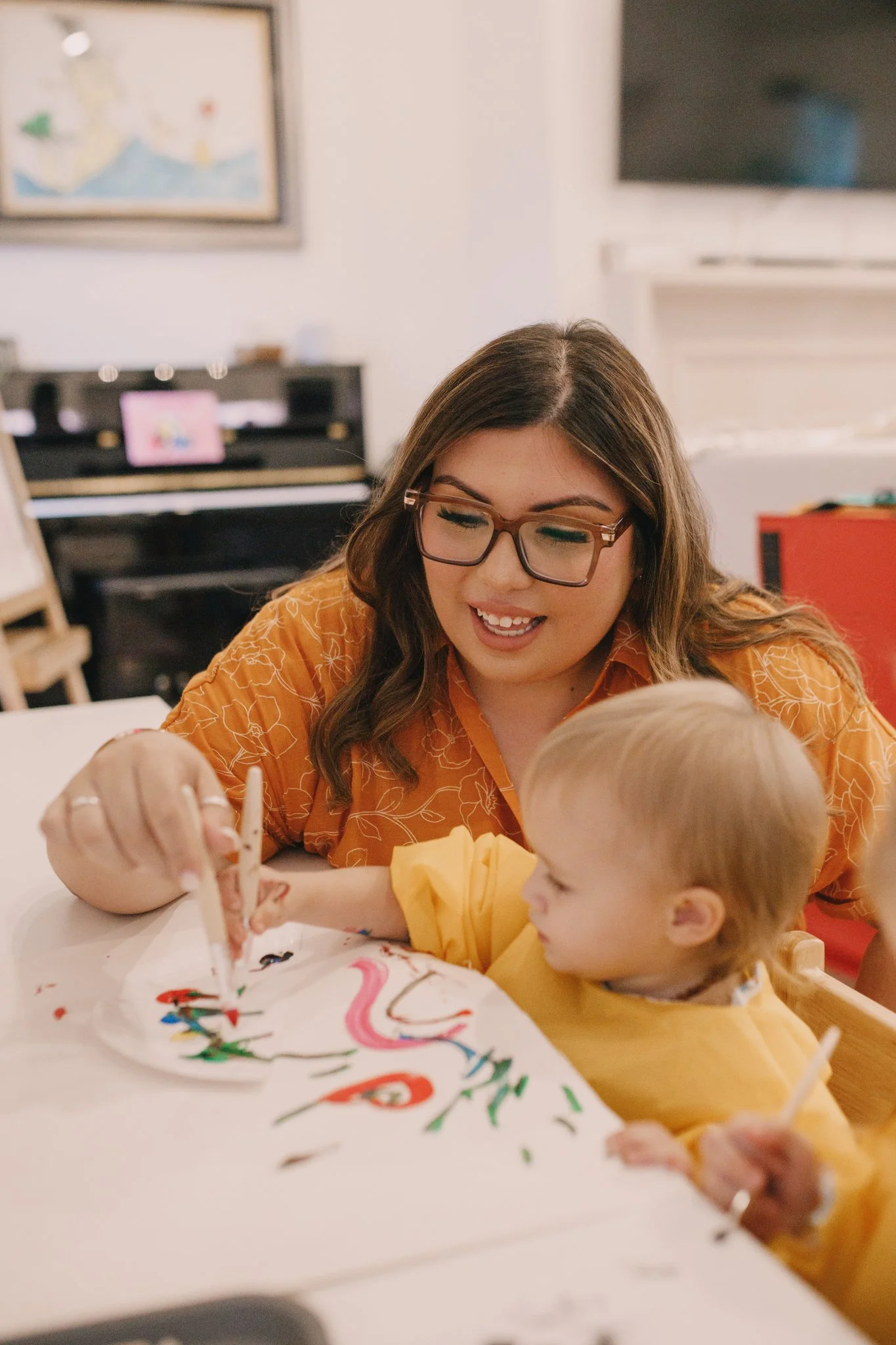adult and young child painting together at table