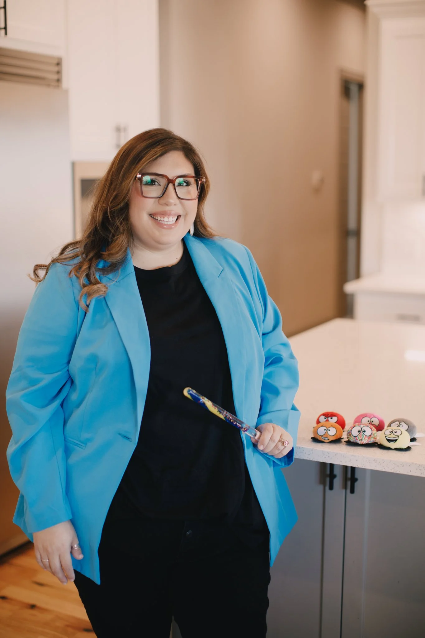 woman smiling and holding a paintbrush