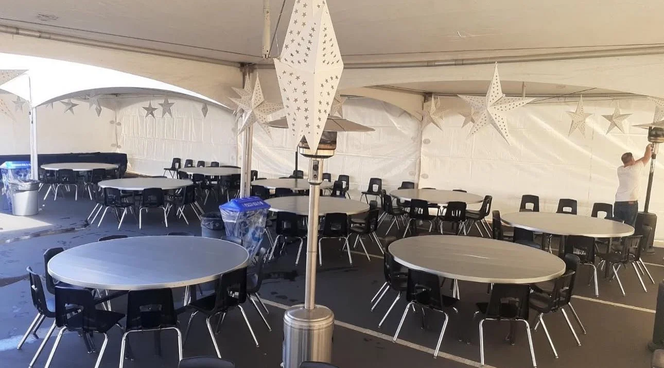 Cozy indoor view of 20x20 tent with string lights and table settings in Sacramento, CA.