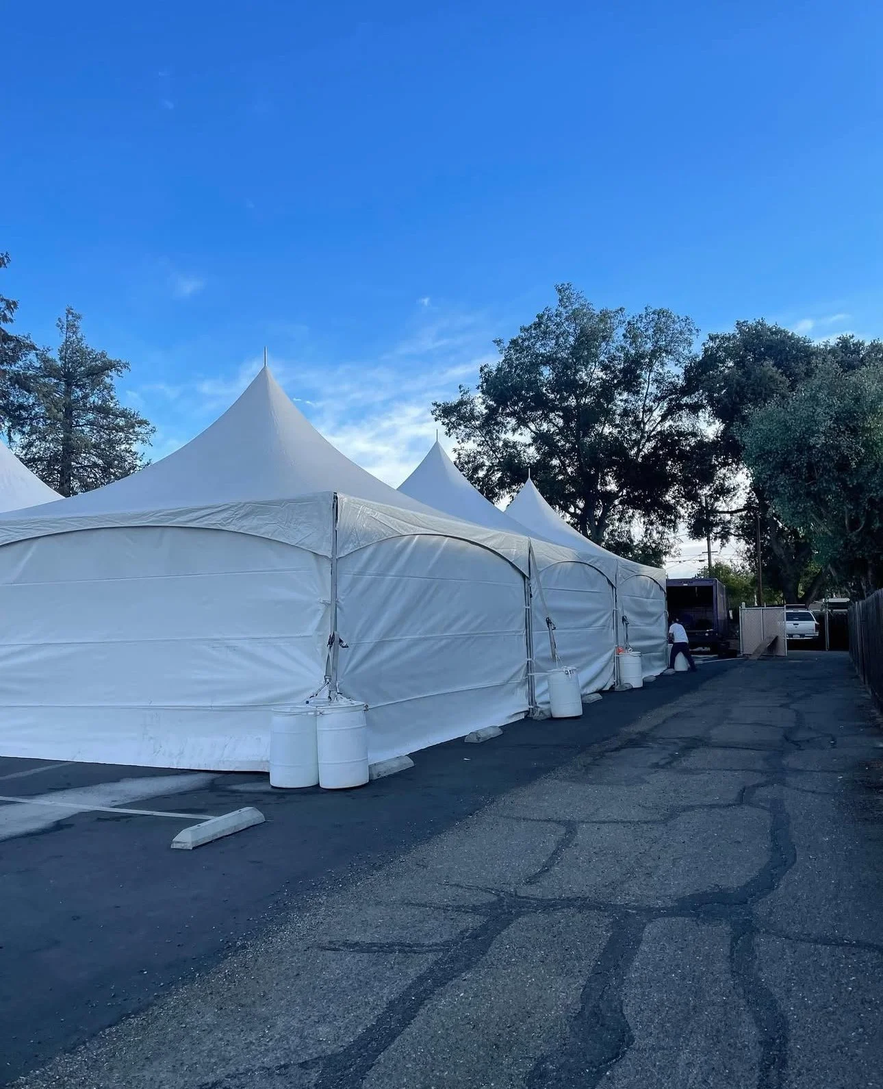 Tents with sidewalls in a parking for a festival.
