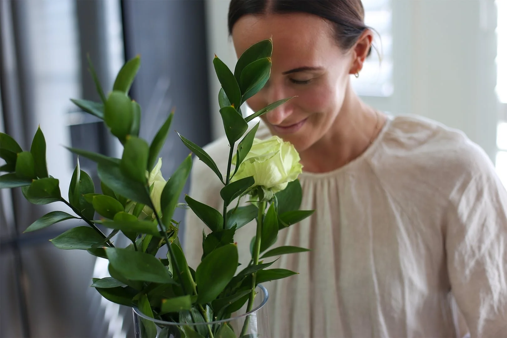 Holistic wellness coach - Alex Ballagh - is taking a quiet moment to smell her flowers.