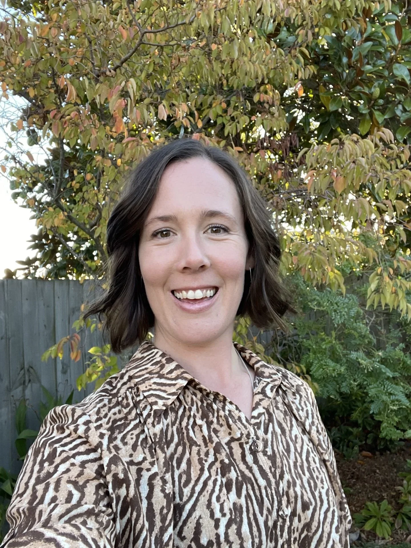 Headshot of a coach client who is smiling at the camera.