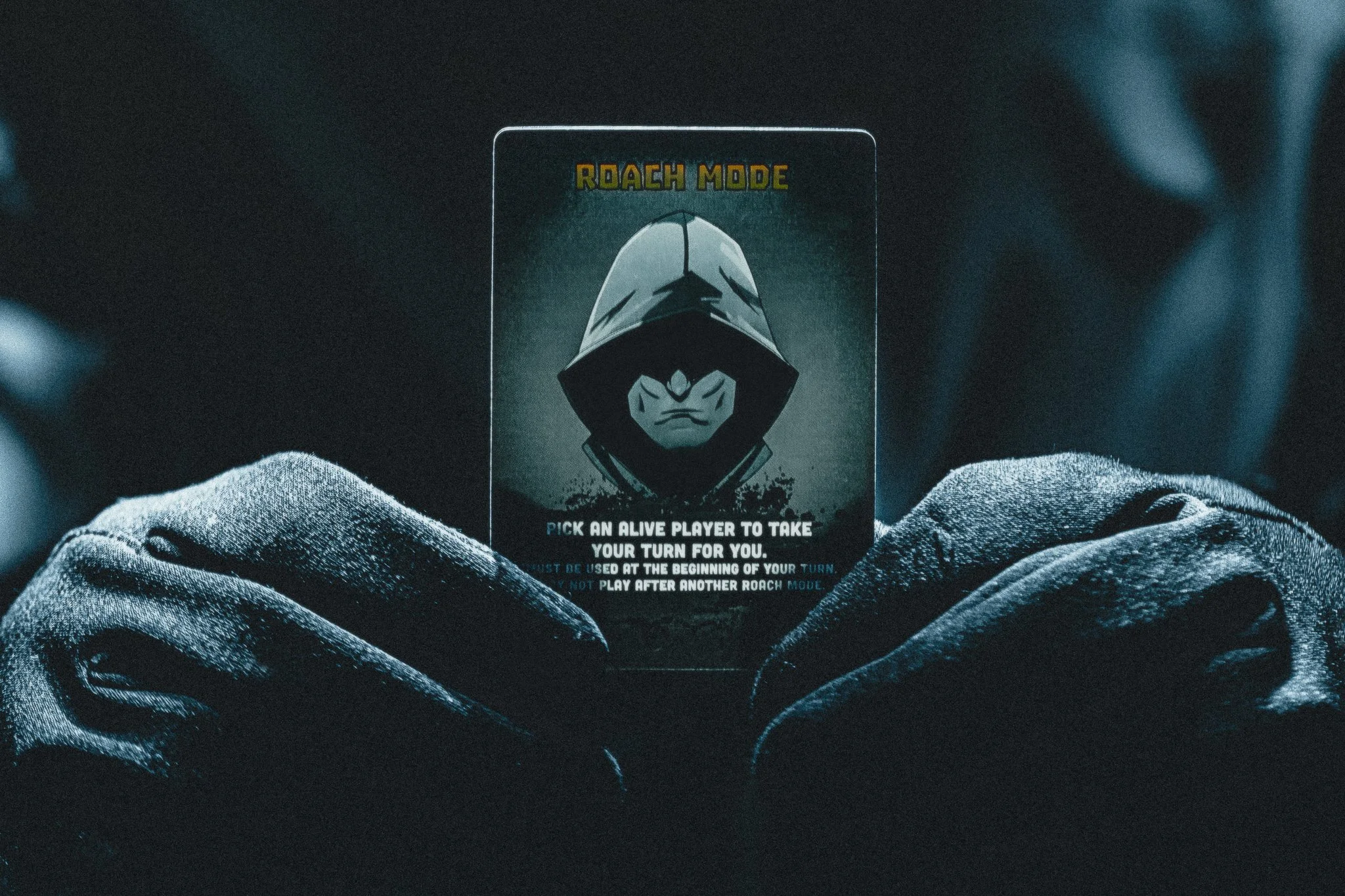 Gloved hands holding Roach Mode card from Zeta Survival card game, product campaign photography