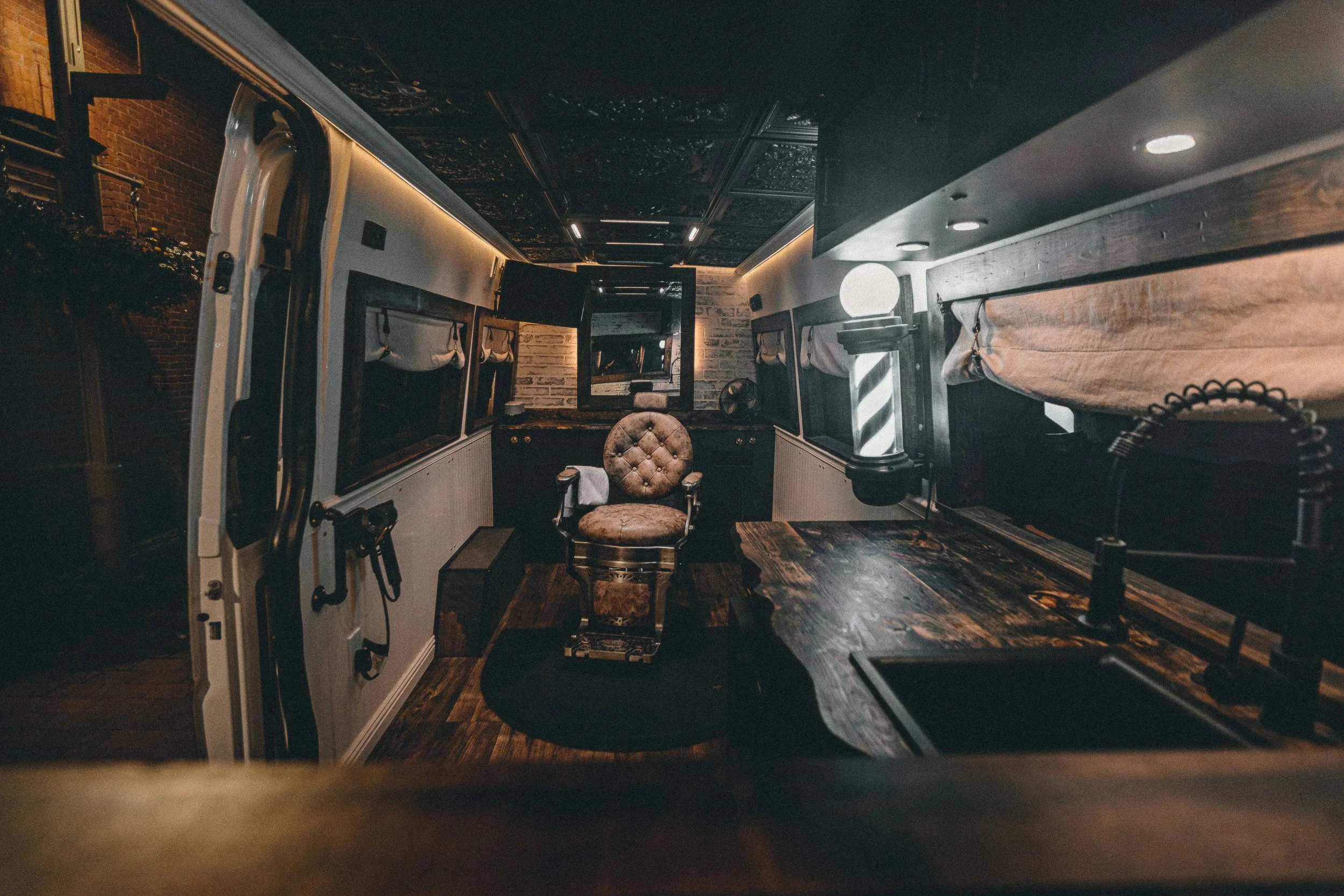 High angle view of leather barber chair with towel and barber pole inside the Nomad Mobile Barbershop van, editorial detail photography by James Brasier
