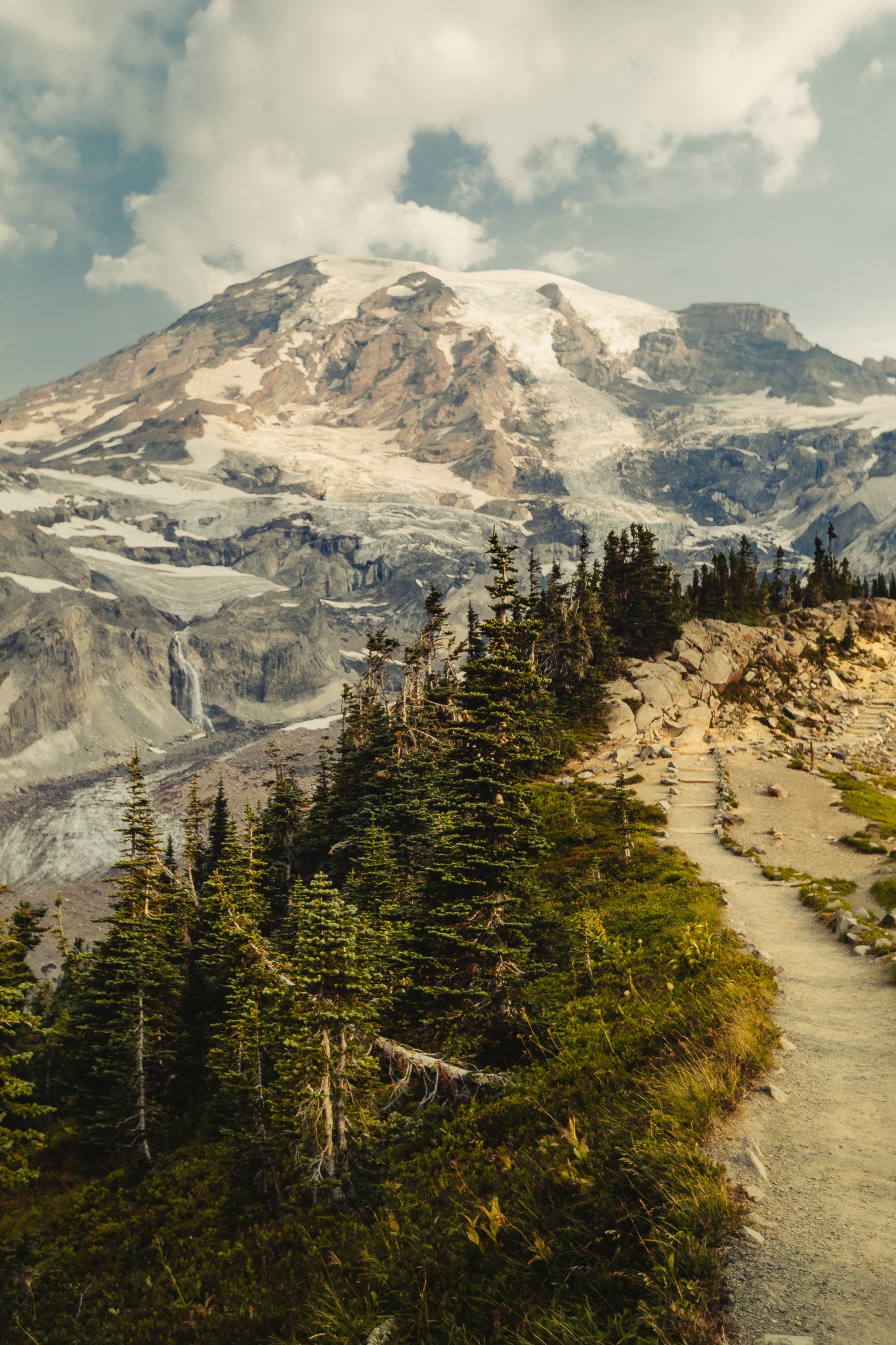 Hiking trail leading toward Mount Rainier with glaciers and wildflowers, mountain landscape photography