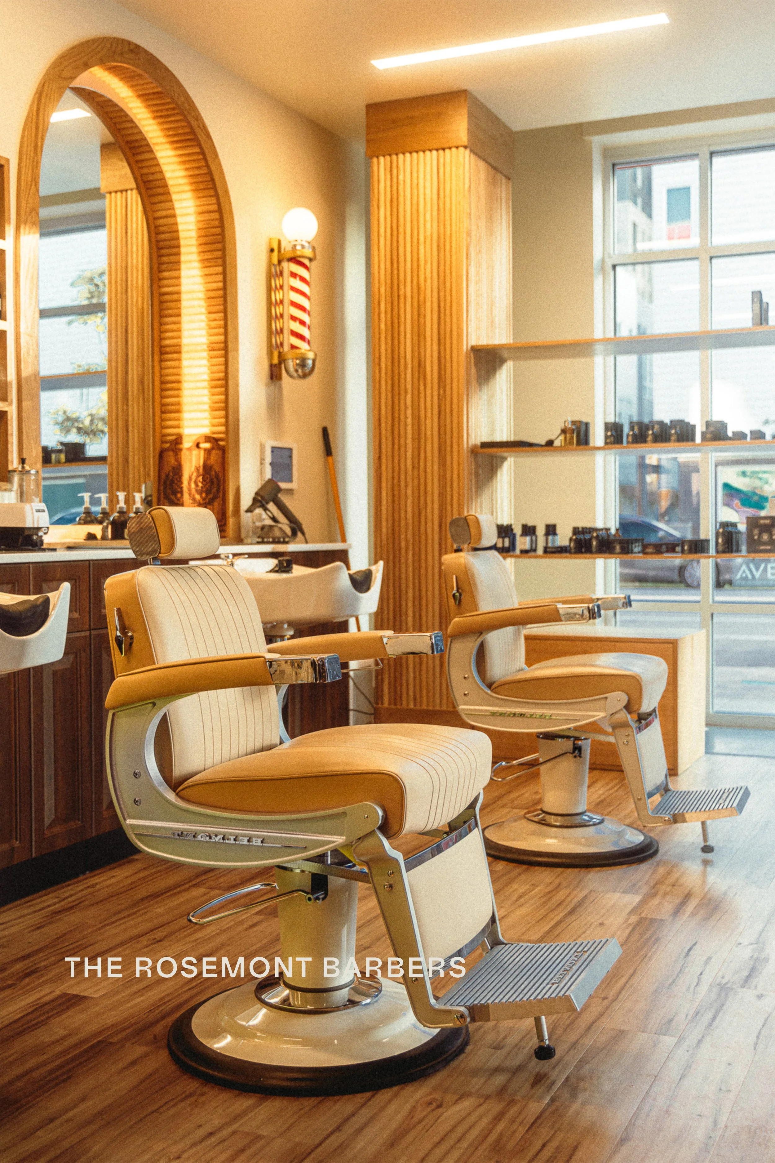 Vintage barber chairs with arched mirror and barber pole in warm natural light at The Rosemont Barbers in Denver, commercial interior photography by James Brasier