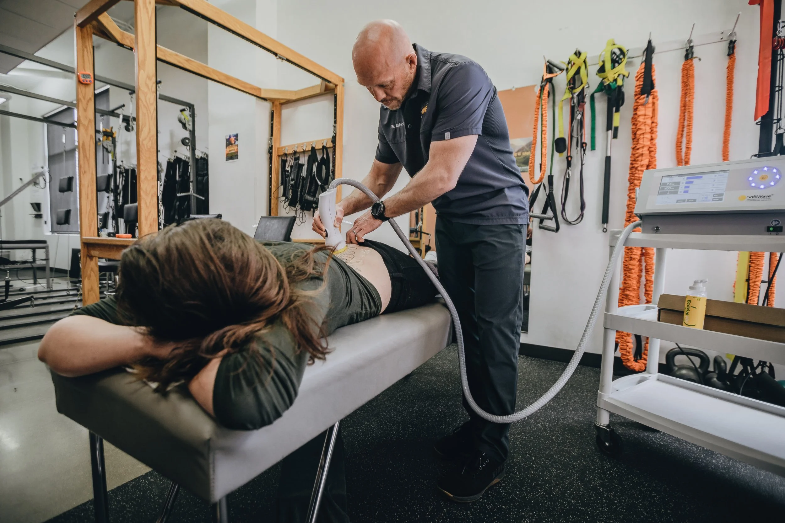 Softwave therapy treatment on lower back at Square One Health clinic, commercial photography by James Brasier