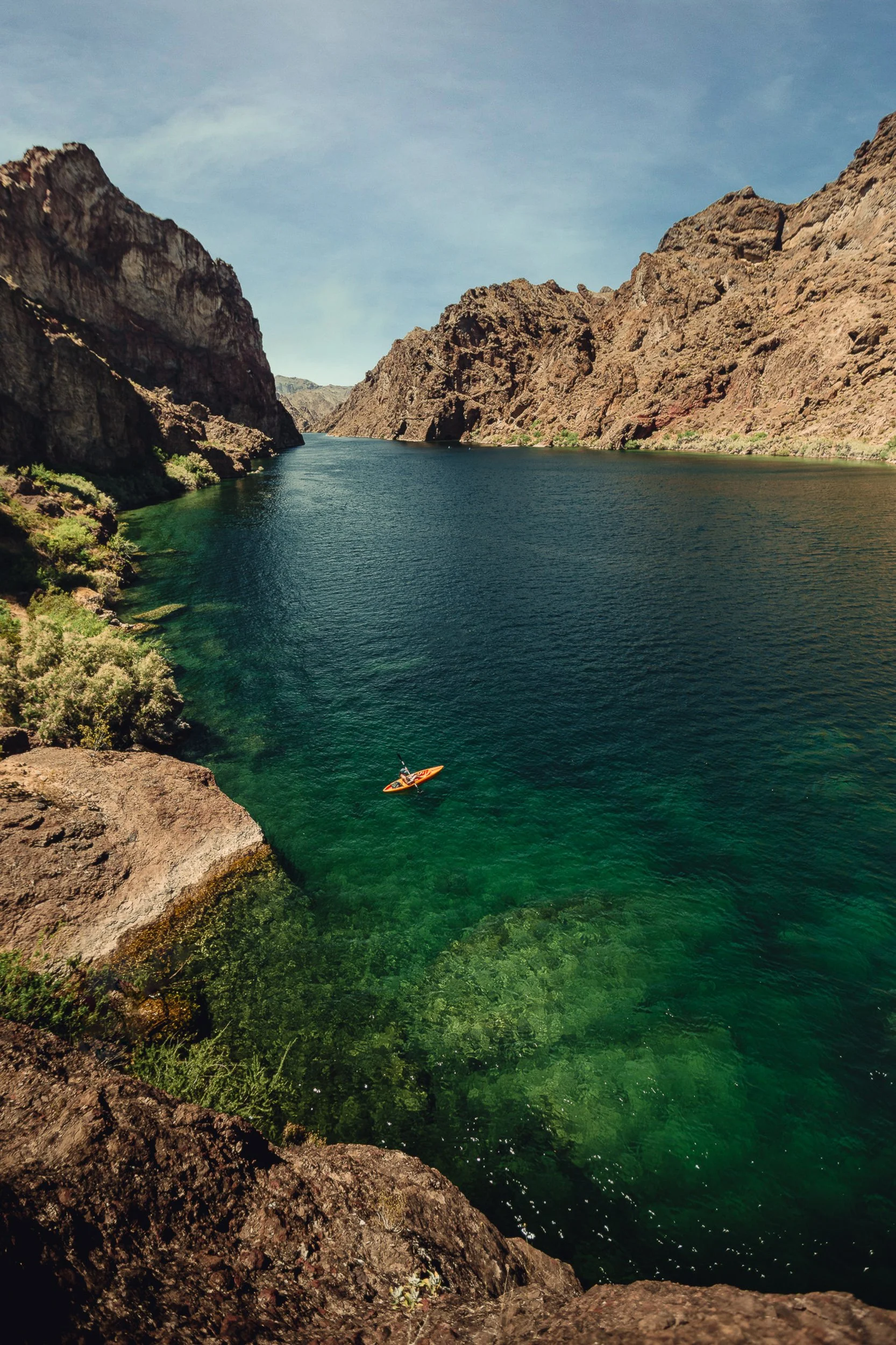 Kayaker in turquoise water between canyon walls at Emerald Cove on the Colorado River in the Mojave Desert, outdoor photography by James Brasier