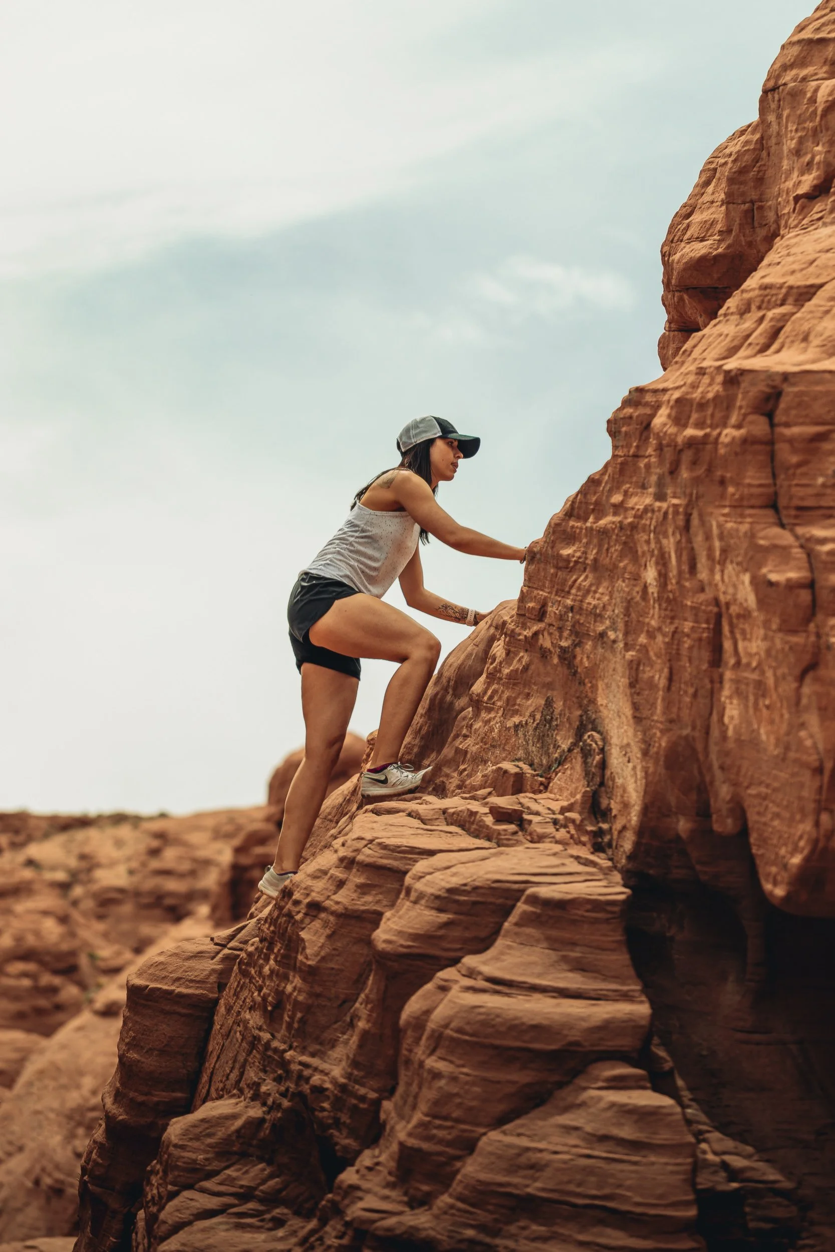 Person climbing a red sandstone formation at Valley of Fire State Park Nevada, desert adventure photography by James Brasier