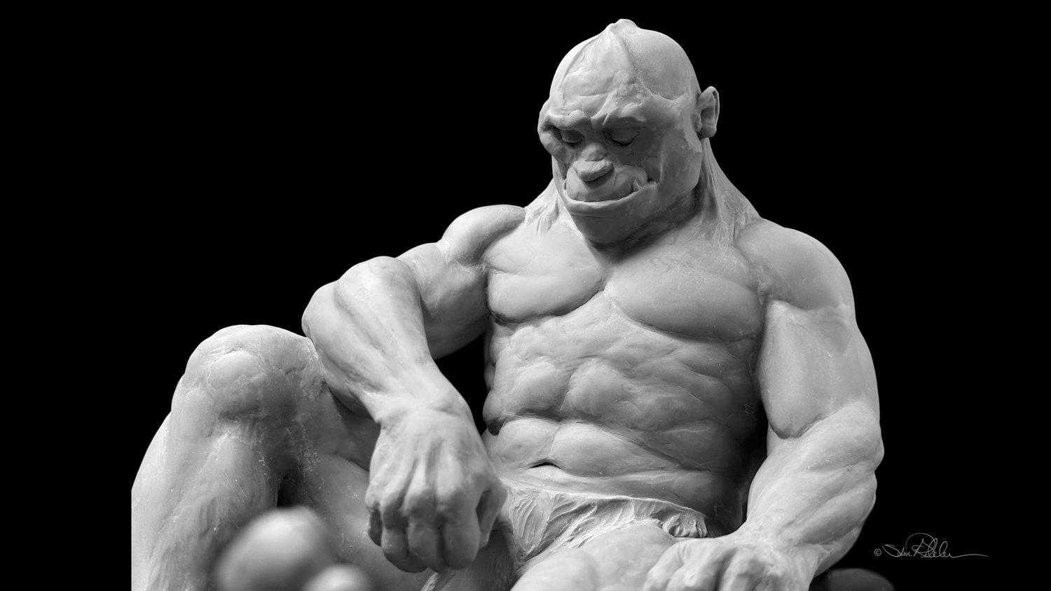 Sculpture in grey epoxy resin of a muscular sleeping giant closeup resting against rocks and boulders with one arm resting on his leg and the other on a boulder in a dark Cave.