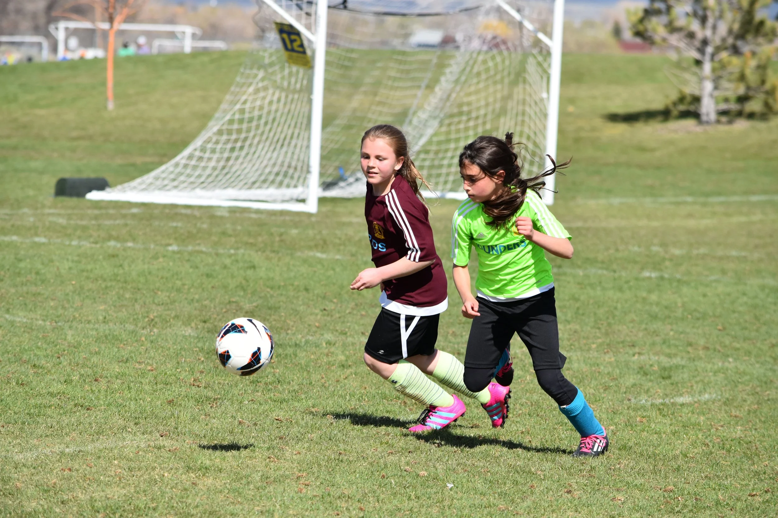 Girls kick soccedr ball