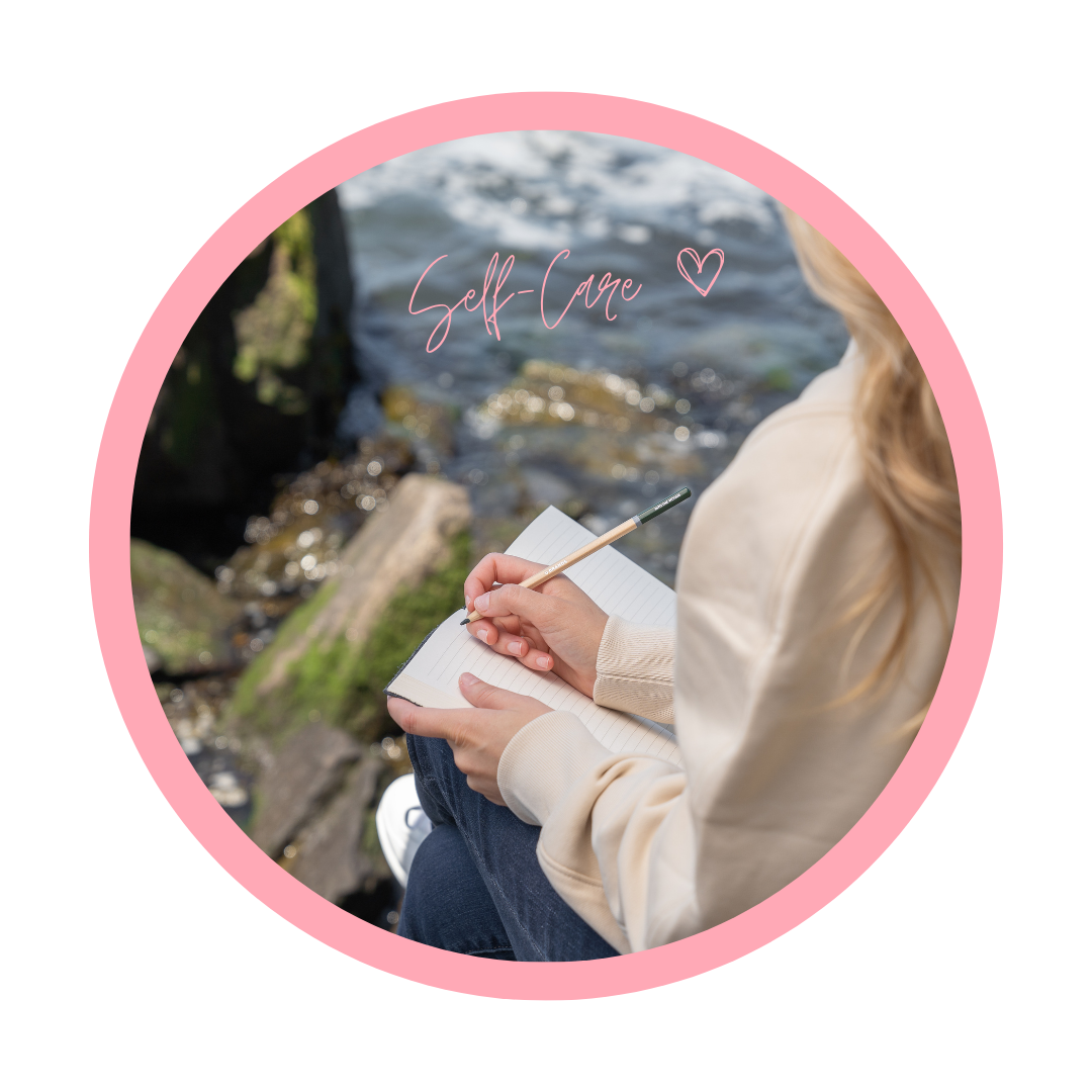 A woman sitting by a river, writing in a notebook, with the text 'Self-Care' and a heart icon overlayed, emphasizing self-care and mindfulness.