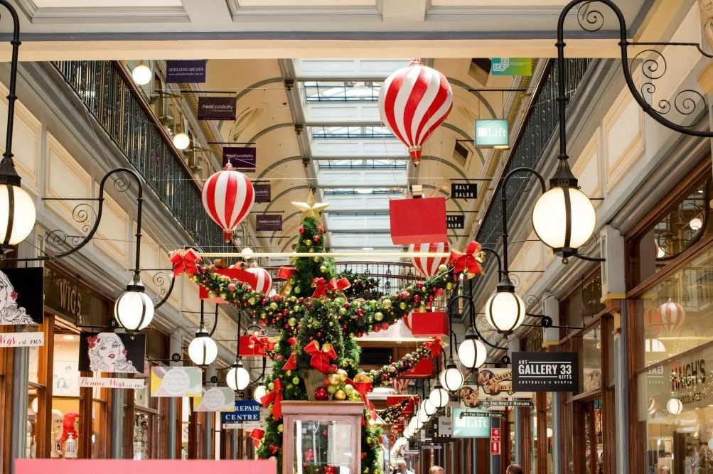 Hot air balloons holding red xmas presents displayed in adelaide arcade.
