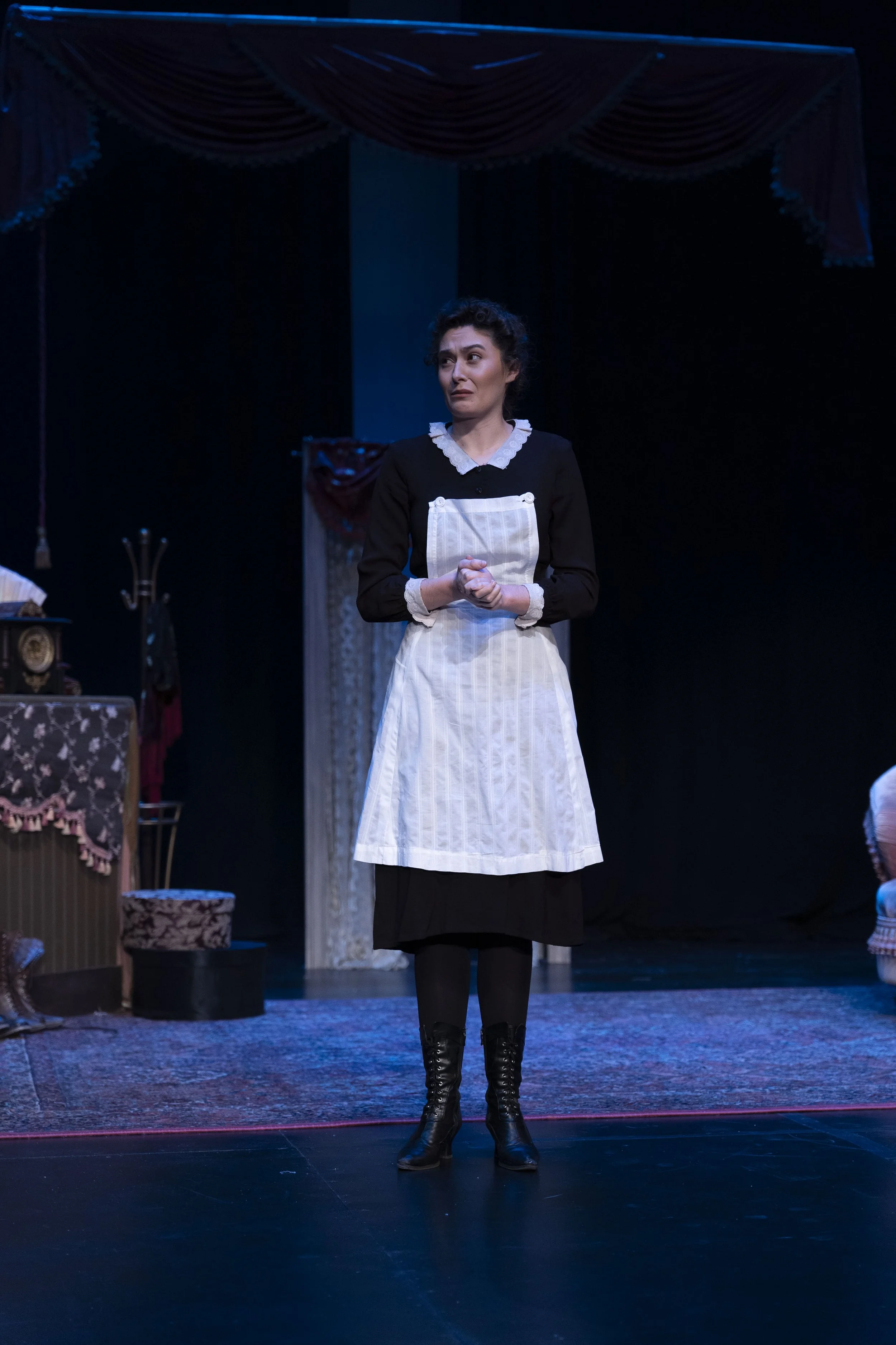 Emily Michelle Walton as Phyllis in Passion, Poison, and Petrifaction, part of Shaw! Shaw! Shaw! at the Shakespeare Theatre of New Jersey, standing onstage in a Victorian maid's uniform with a serious expression.