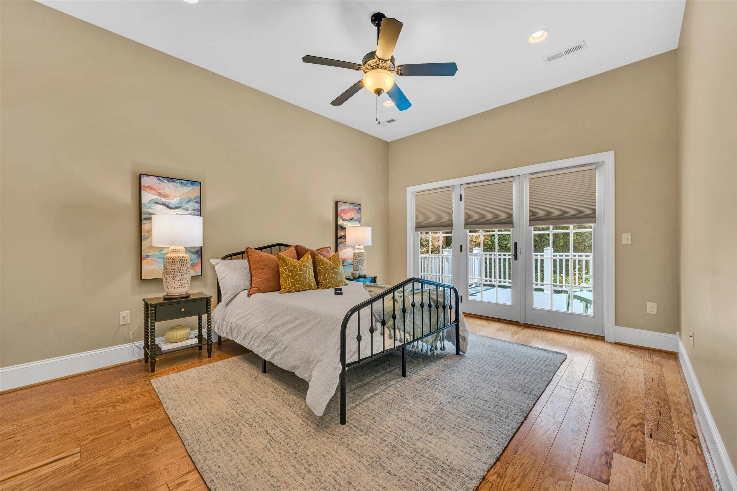 Dining room with a wooden table, a chair, a small wooden console table, a window with white curtains, and a light-colored wall with a lighthouse picture.