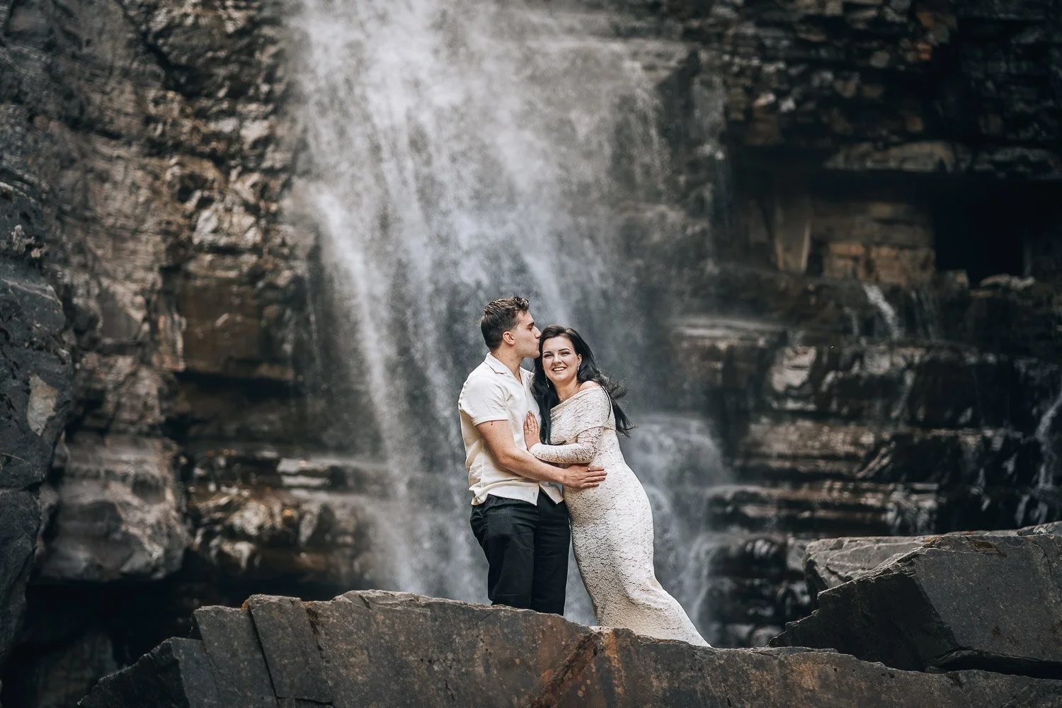 Engagement photo next to waterfall