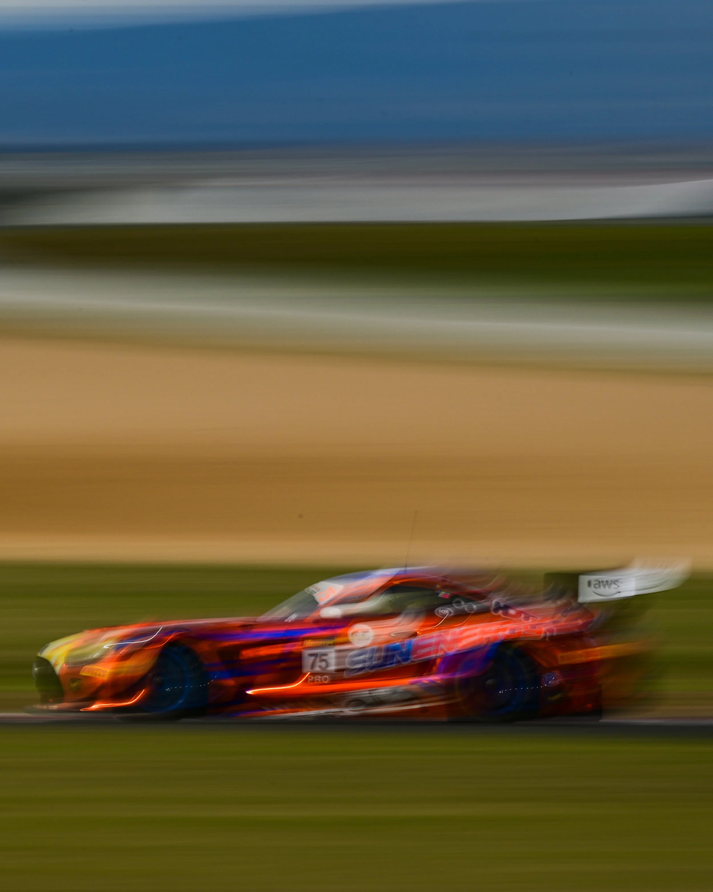 A race car speeding on a track, with motion blur in the background.