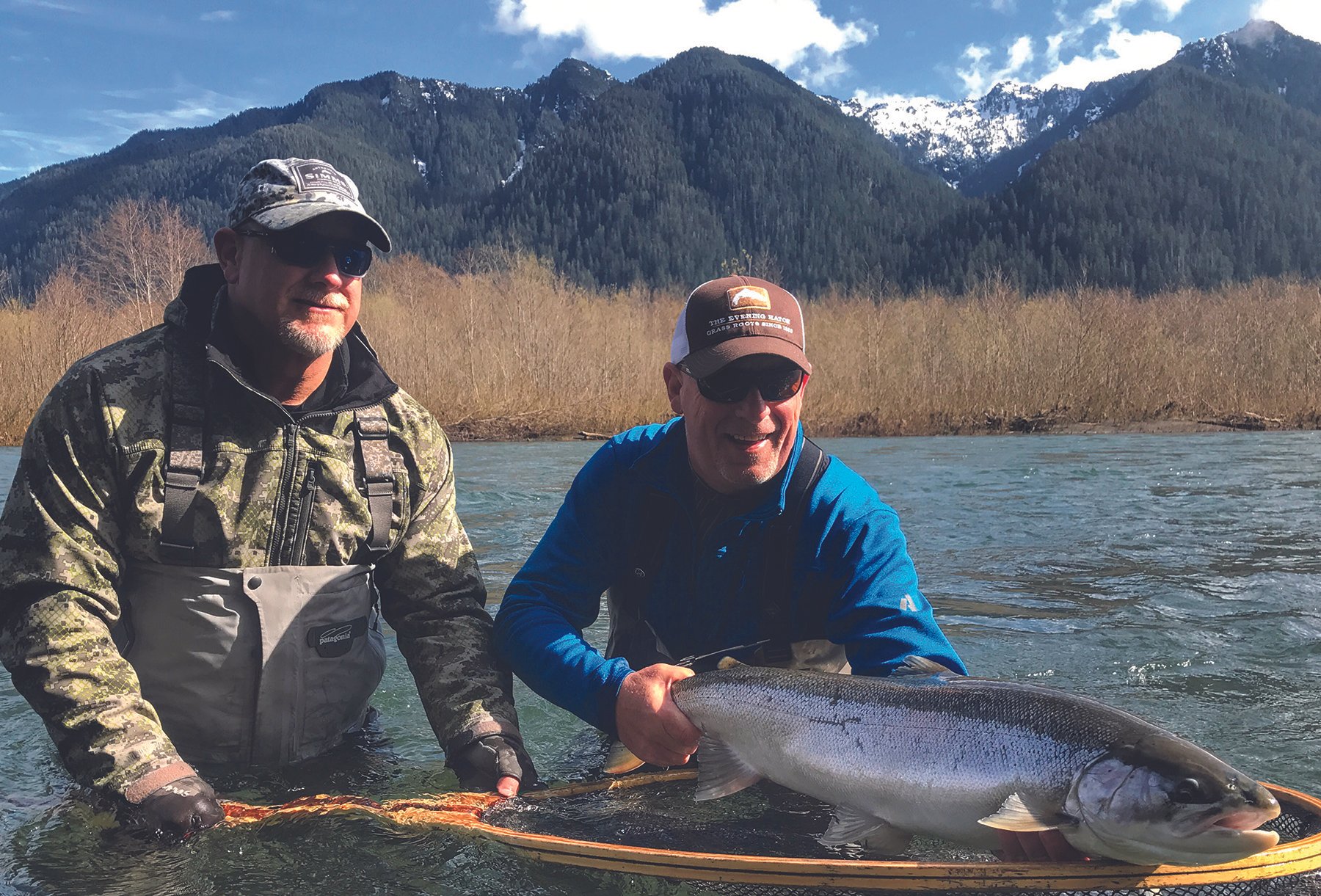 Image of two anglers on the Quinault River with a large steelhead.