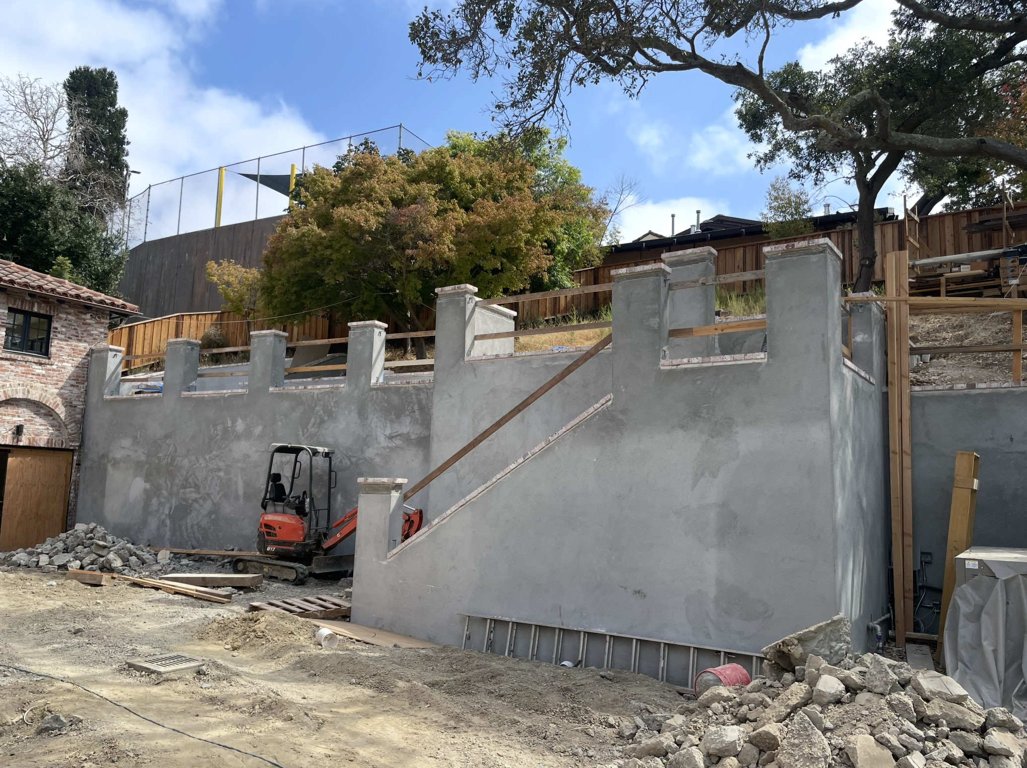 Construction site with concrete wall and excavator