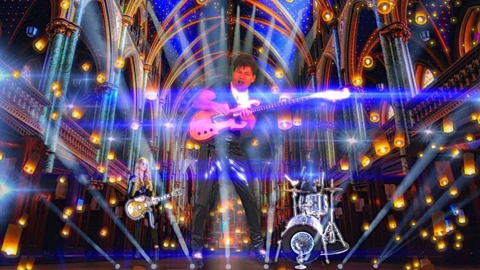 Sam DeRose Jr performing on a brightly lit stage with vibrant lights and an elaborate background, including a man in the center playing an electric guitar, a woman on the left playing a guitar, and a drum set on the right.