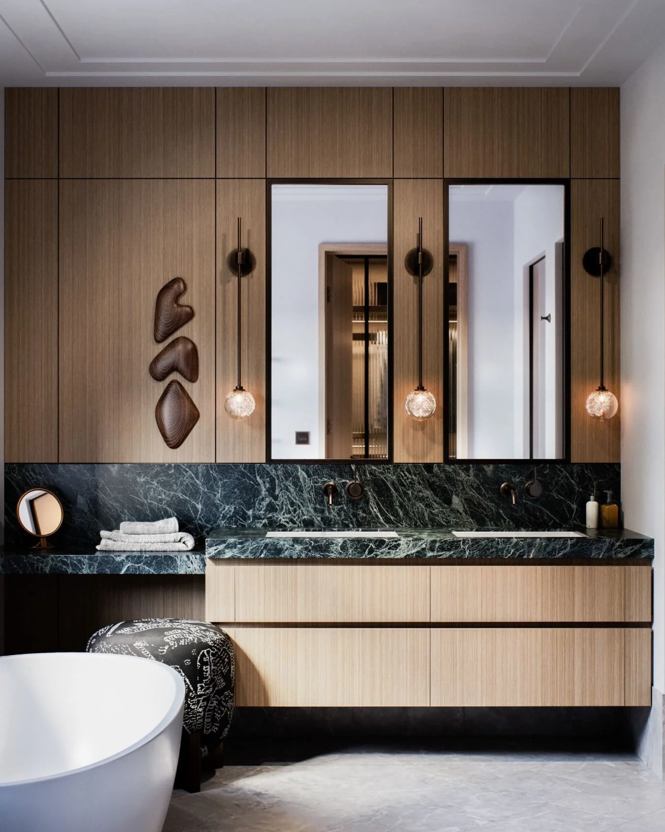 The contemporary master bathroom at our Wimbledon Walled Villas. Striking verde green marble contrasts with the timber wall and vanity finishes, while the bespoke built-in dressing table adds a practical yet playful feature. Designed with a freestand