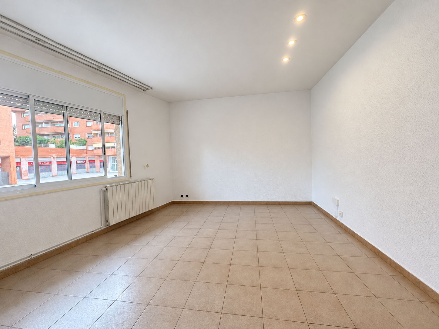 Salón vacío con ventana urbana.png