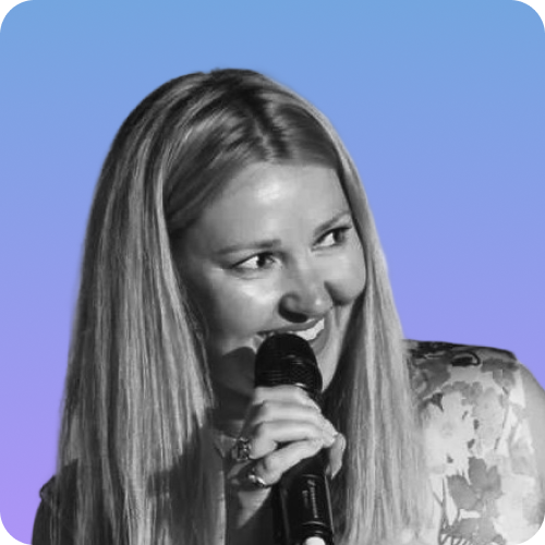 Image of Joss Tasker, woman with long hair and a microphone in her hand smiling