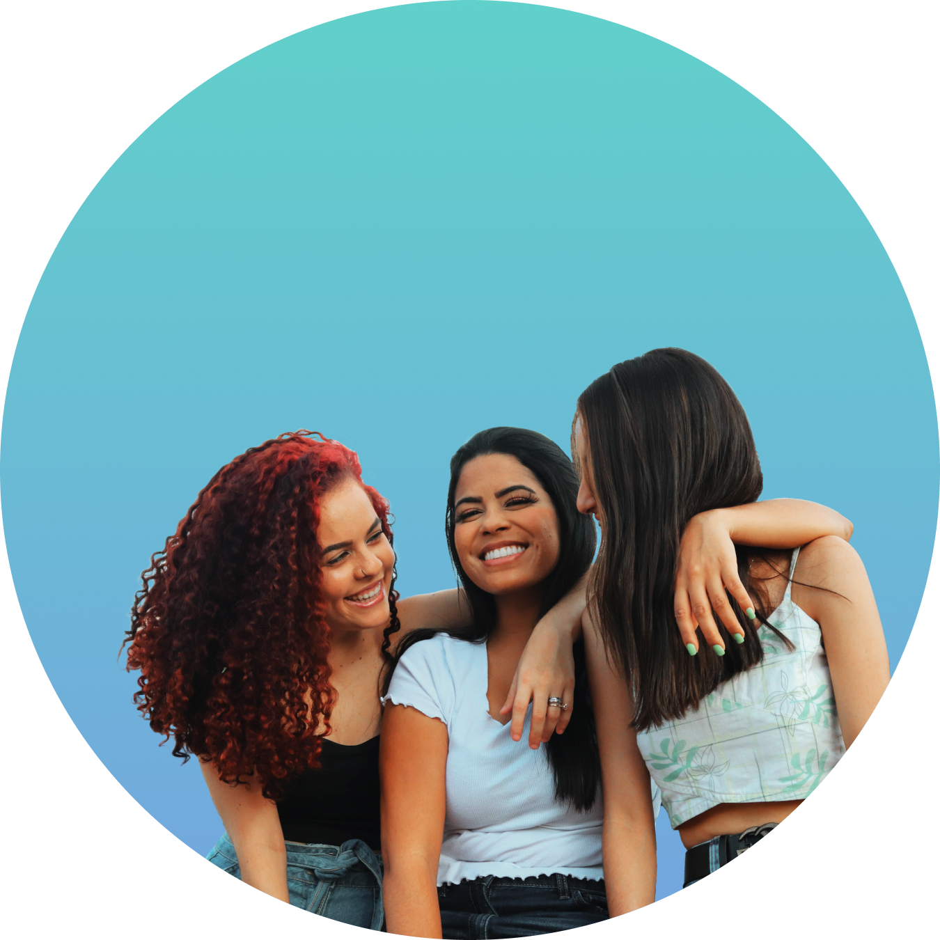 Group of three women hugging and smiling against a blue background.