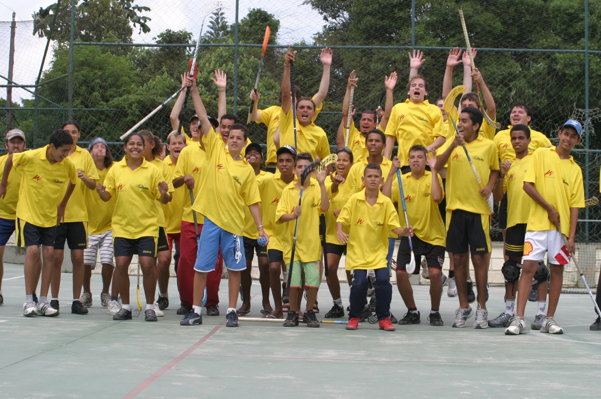 Jubelndes Unihockey-Team in gelben Trikots in Brasilien – Symbol für Step-Einsätze: Teameinsätze von 3 bis 4 Wochen in Südamerika oder Spanien.