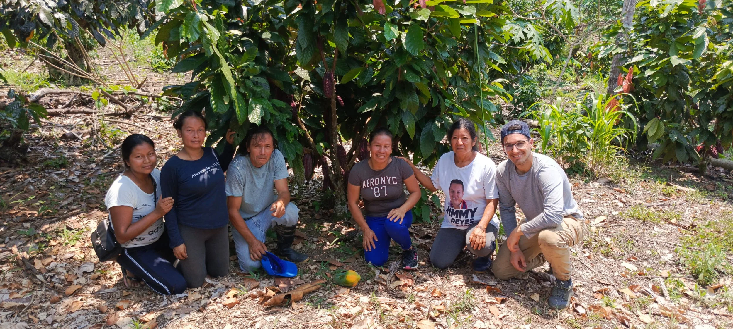 Ehemaliger Kurzzeiter mit fünf lokalen Personen in der Hocke auf einem Feld – alle blicken in die Kamera. Zeigt die vielfältigen, individuell zugeschnittenen Einsätze bei Latin Link, bei denen du deine Gaben in Südamerika sinnvoll einbringst.