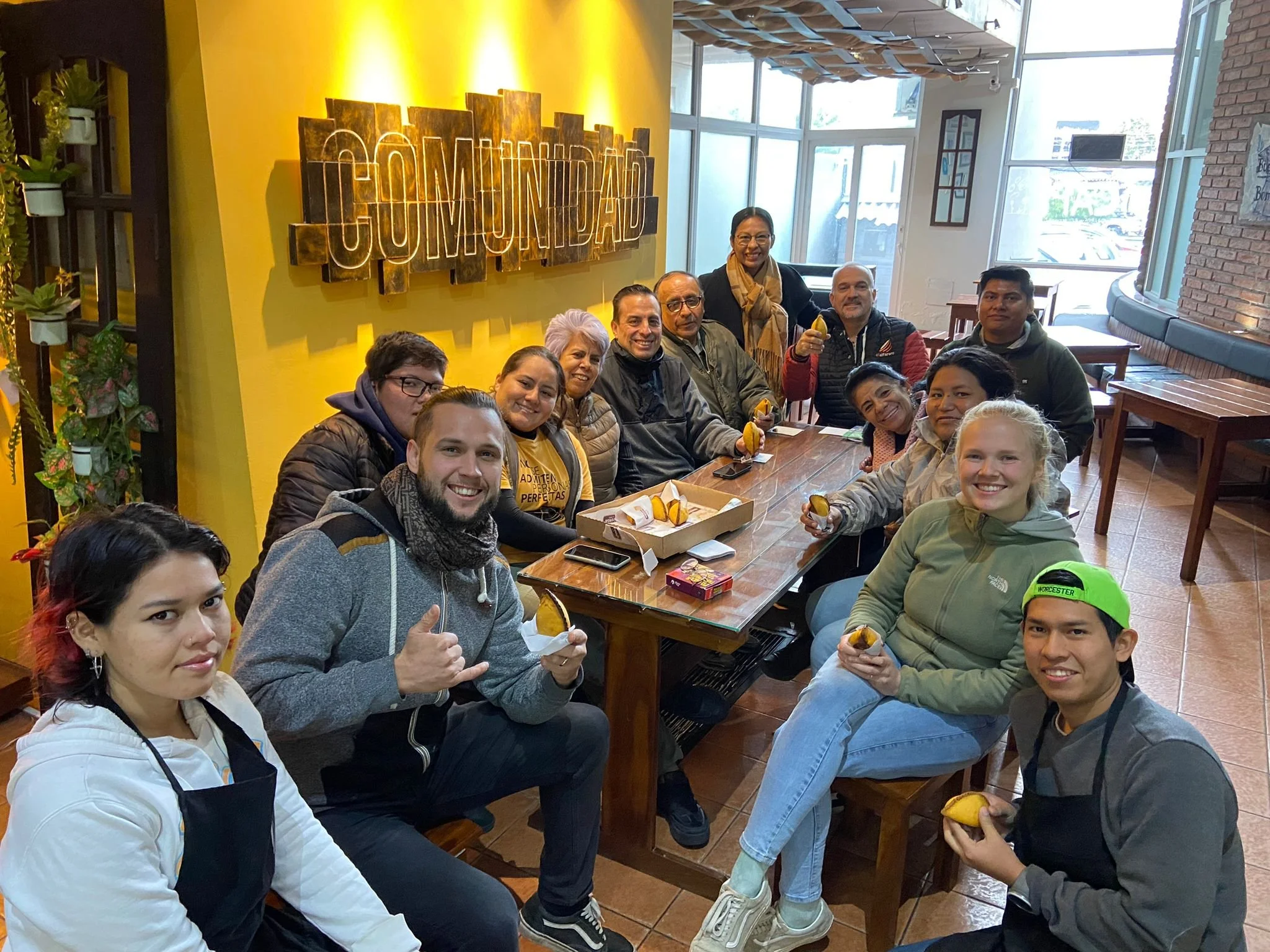 Ehepaar während ihres Kurzzeiteinsatzes in einem Café in Bolivien – sitzt am Tisch mit lokalen Mitarbeitenden und blickt in die Kamera. Stride-Kurzzeiter berichten von ihren Erfahrungen während ihres Einsatzes in Lateinamerika.