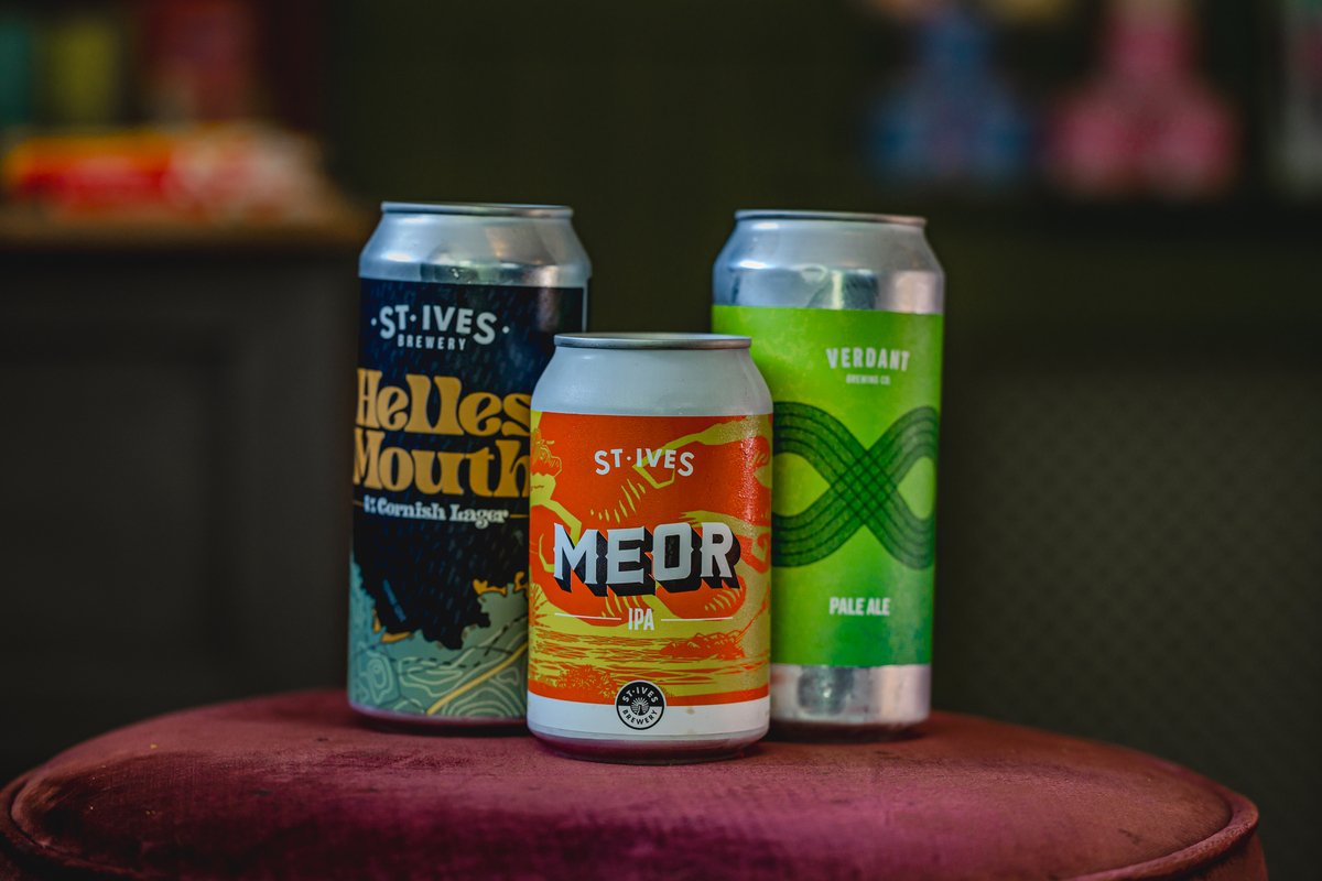 Three craft beer cans on a stool: a St Ives Brewery Helles Mouth Cornish Lager, a St Ives Meor IPA, and a Verdant Brewing Co. Pale Ale.