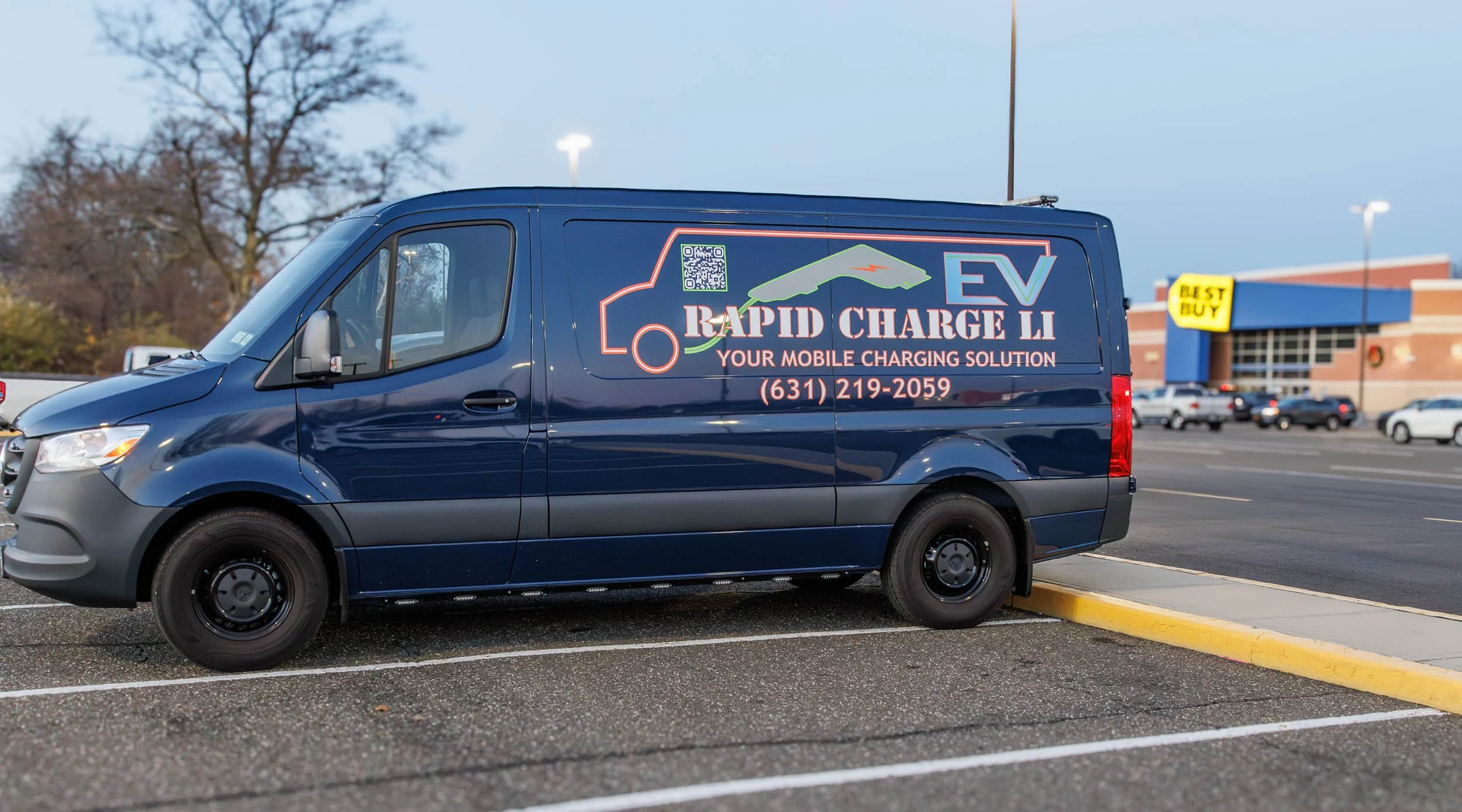 Company van with advertising for EV rapid charging solutions, including a QR code, phone number, and slogan.