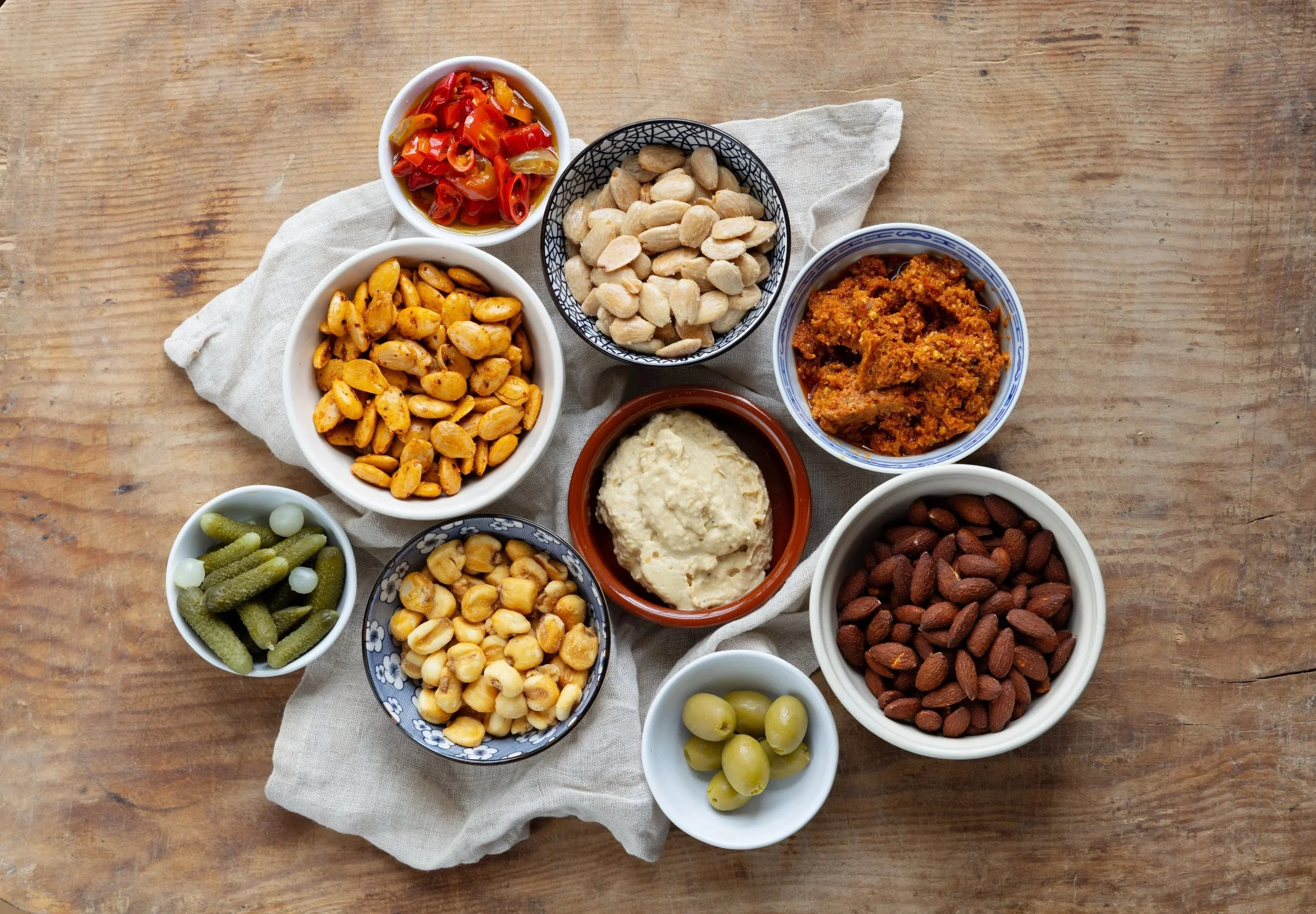 Selection of nuts, hummus, olives and cornichons