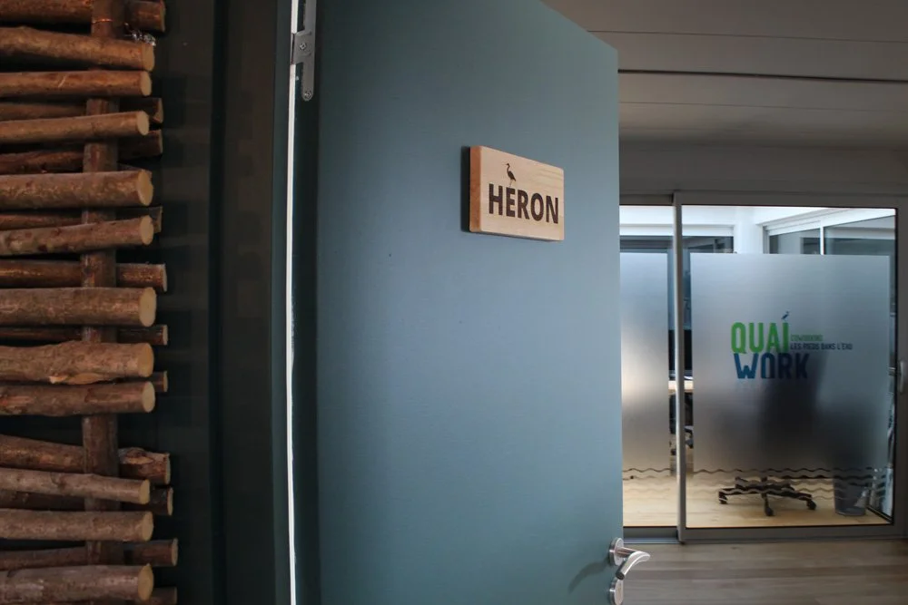 Signalétique intérieure en gravure laser sur panneau, affichant des informations claires et esthétiques pour les utilisateurs de l'espace de coworking.