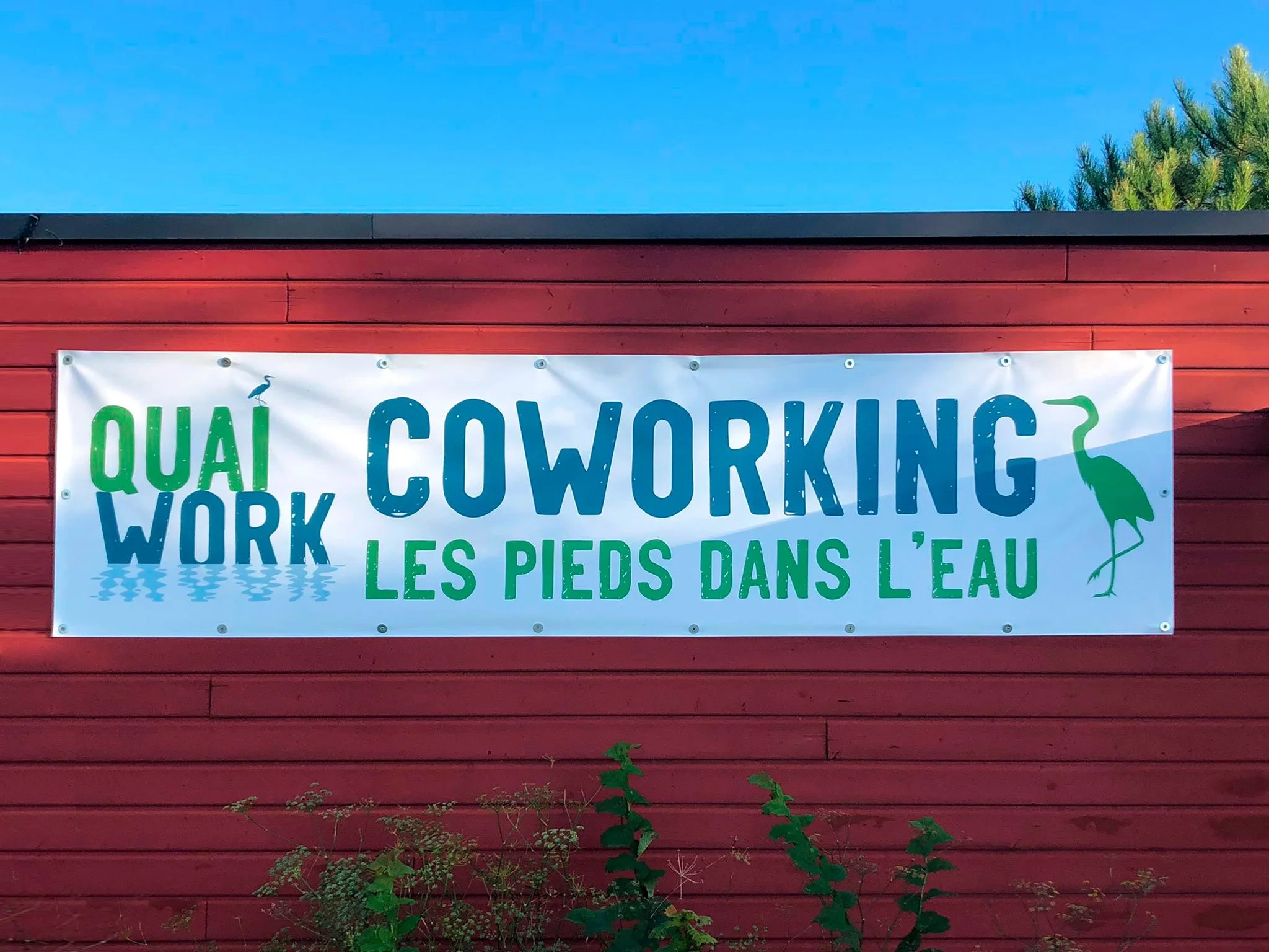 Bâche imprimée installée à l'extérieur sur un mur rouge bardage bois