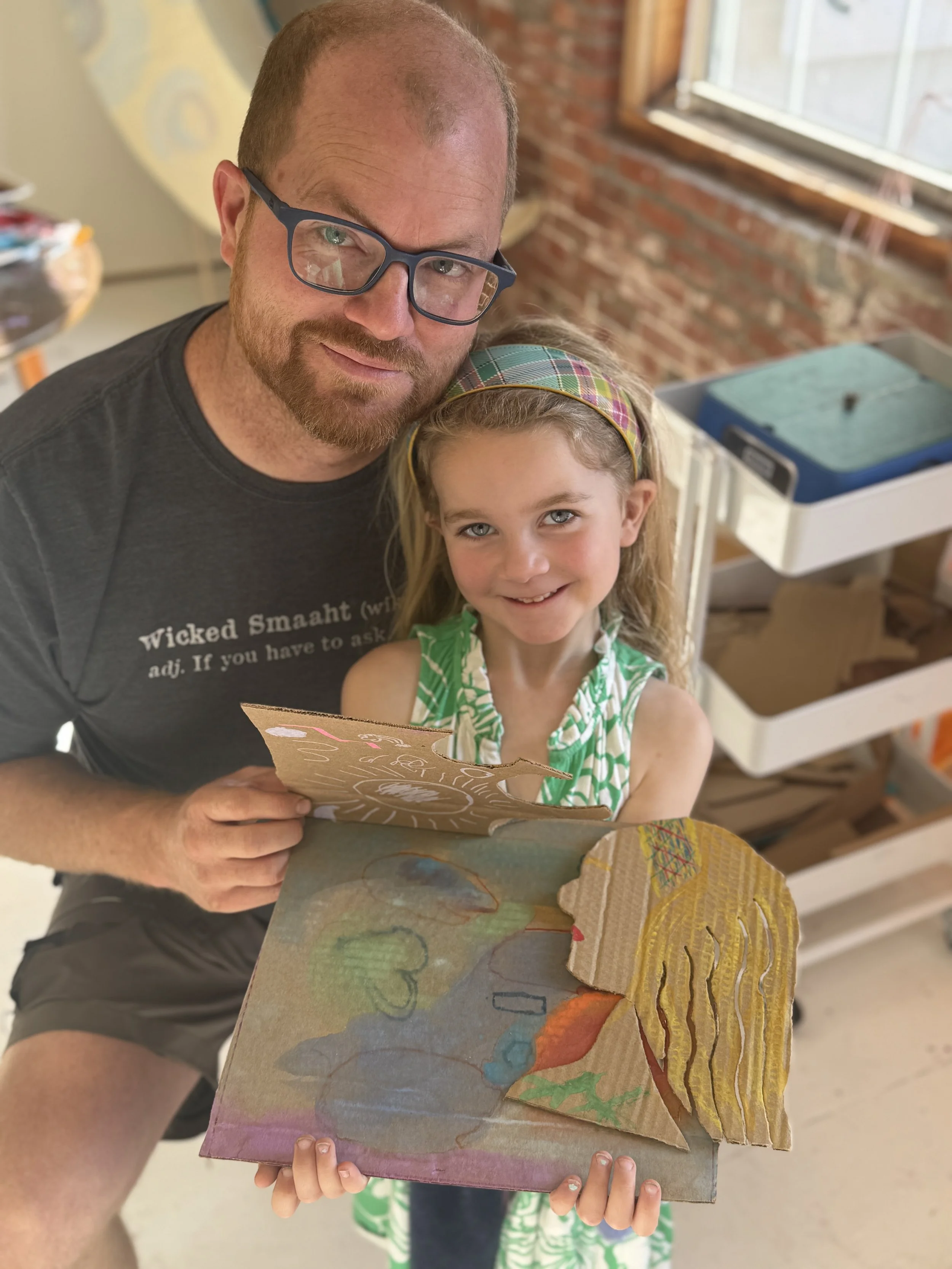IDad and daughter holding a cardboard sculpture