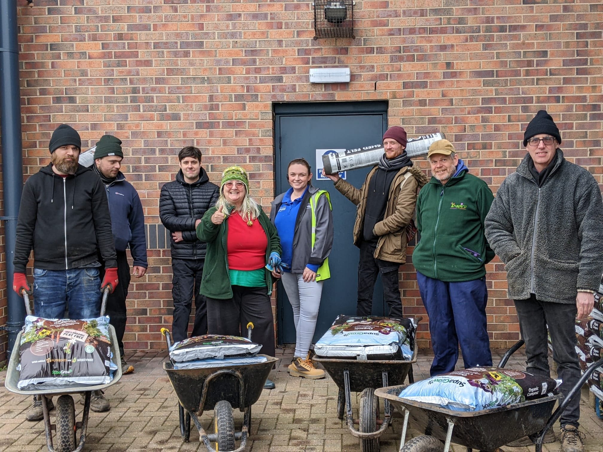 inspire volunteers wheeling compost.jpg