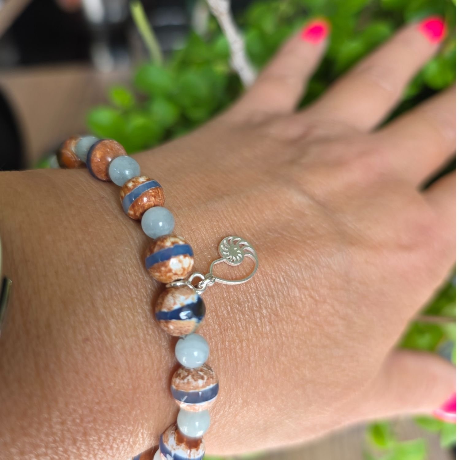 Tibetisches Dzi Achat und Aquamarin Armband getragen am Handgelenk mit 925er Silber Schnecken-Anhänger