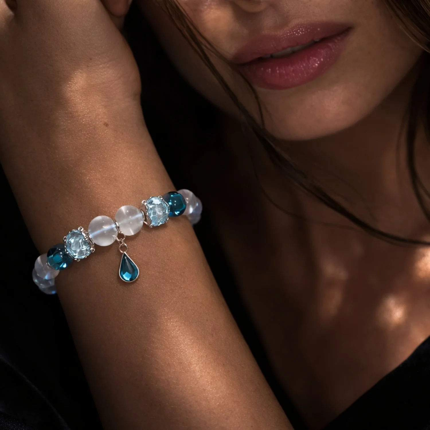 Frau trägt Aqua Aura Bergkristall Armband mit 925 Silber, Blautopas und Muranoglas in eleganter Nahaufnahme