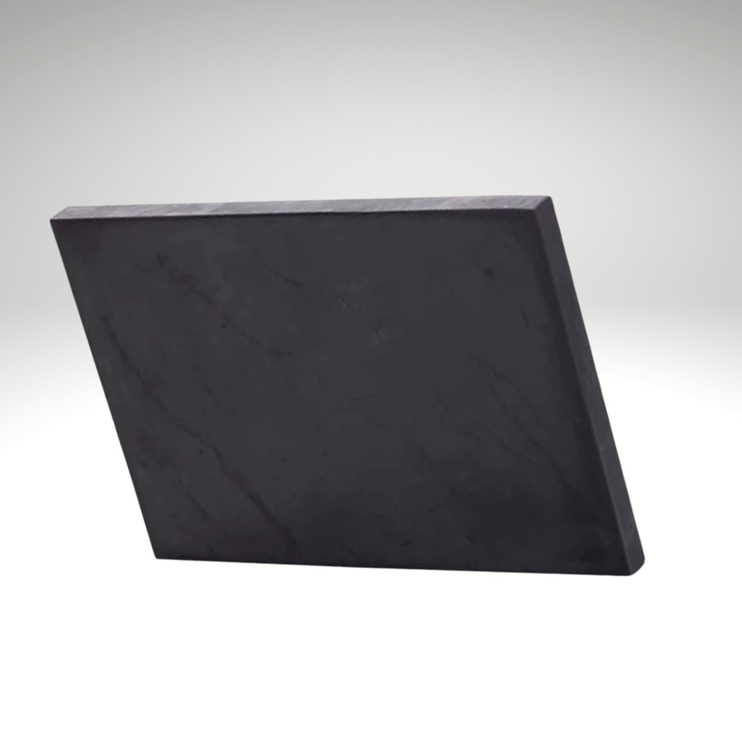 Polierte rechteckige Schungit-Platte aus schwarzem Naturstein auf hellem Hintergrund