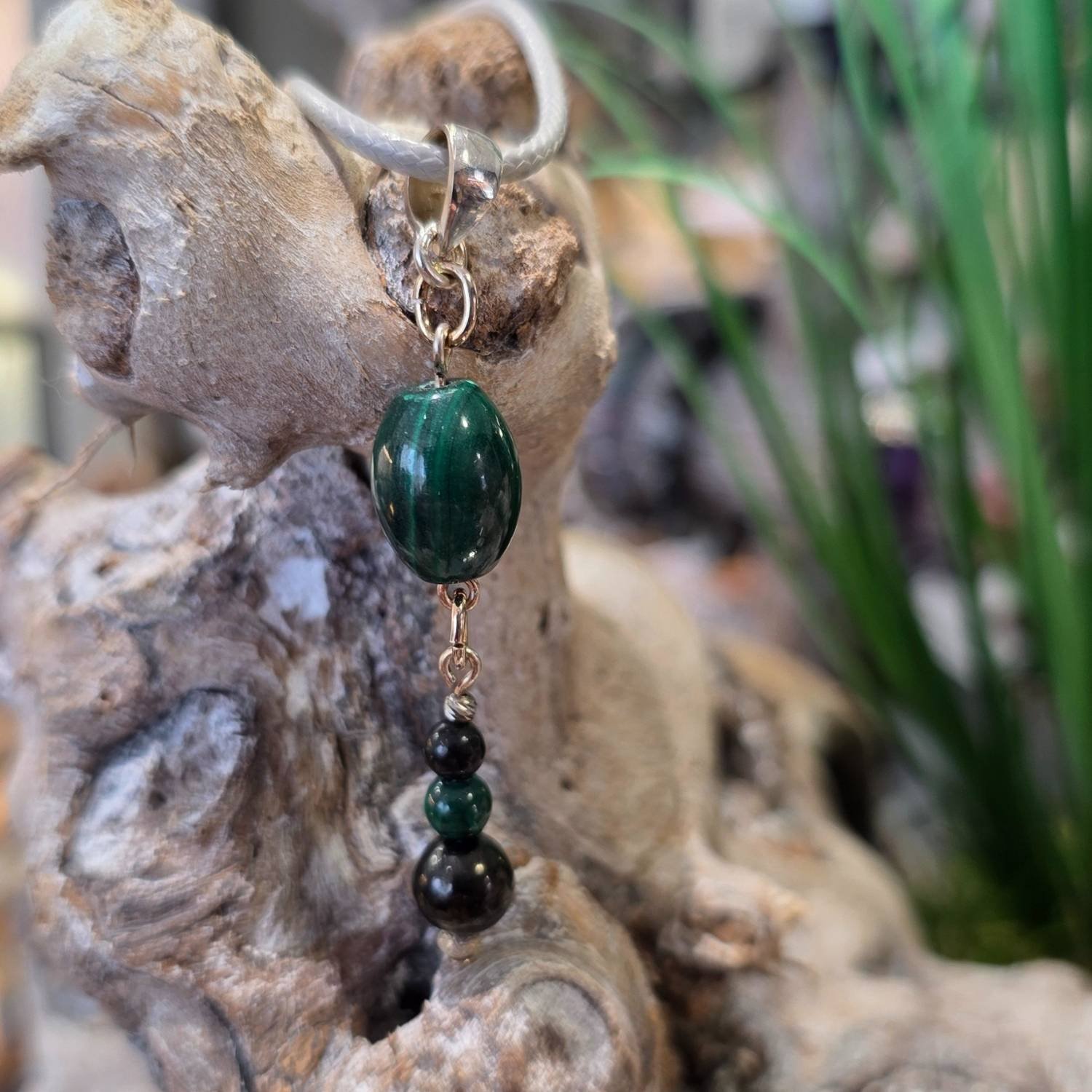 Malachit-Schungit Anhänger mit 925 Silber – spiritueller Edelstein-Schmuck mit grünen und schwarzen Perlen, auf Dekoholz präsentiert