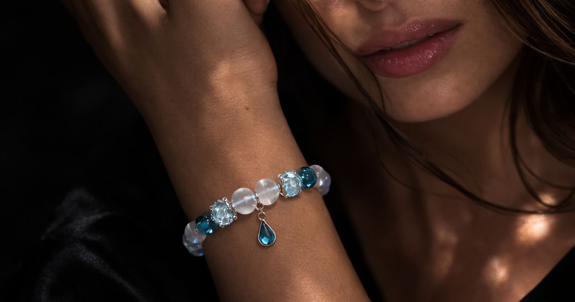 Murano Glas Edelsteinarmband mit mattiertem Bergkristall, hellblauen Murano Glasperlen, Aqua Aura und Topas Tropfenanhänger aus 925 Silber am Handgelenk einer Frau – PRANA Edelsteine Kollektio