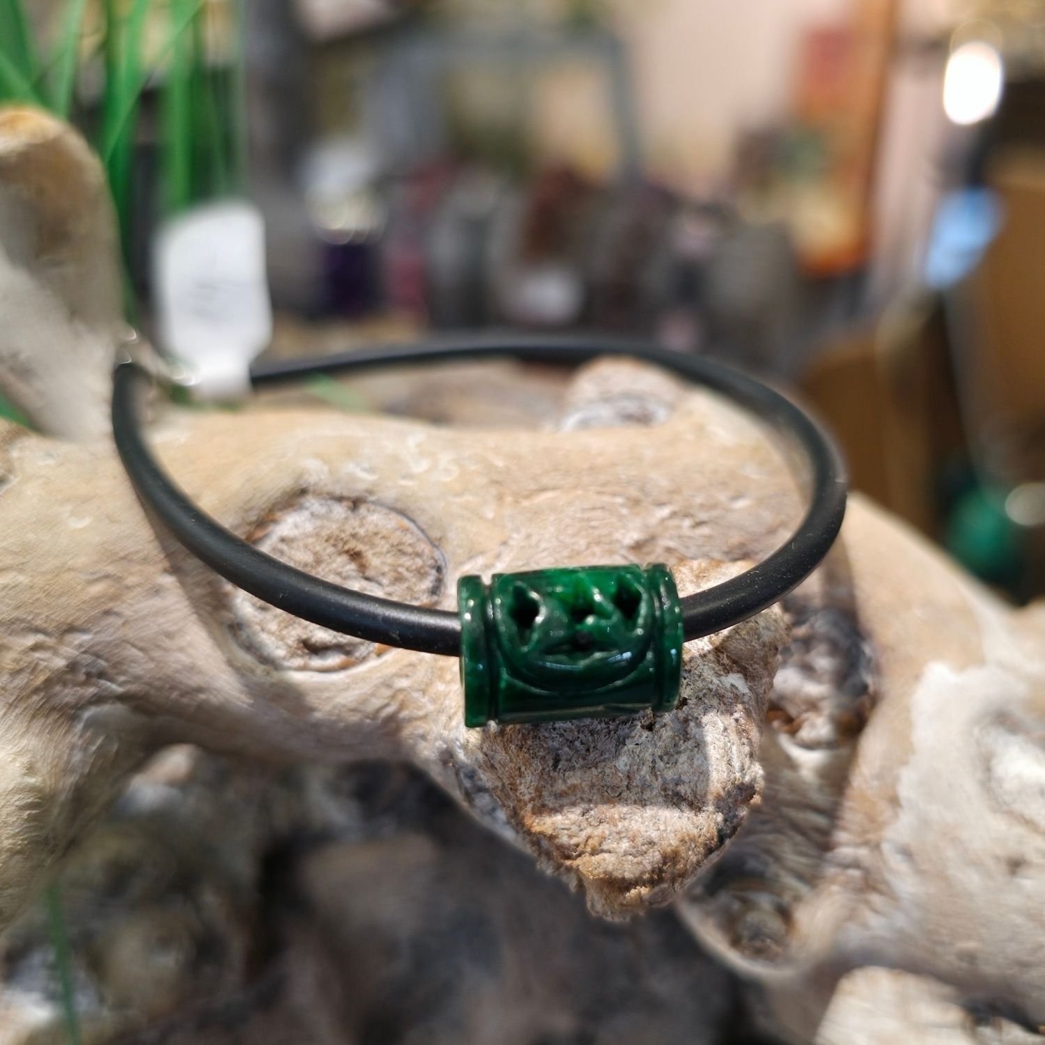 Armband mit handgeschnitztem Burma-Jade-Zylinder auf schwarzem Kautschukband, getragen am Handgelenk, mit 925 Silberverschluss – spiritueller Edelsteinschmuck für Balance und Herzöffnung.