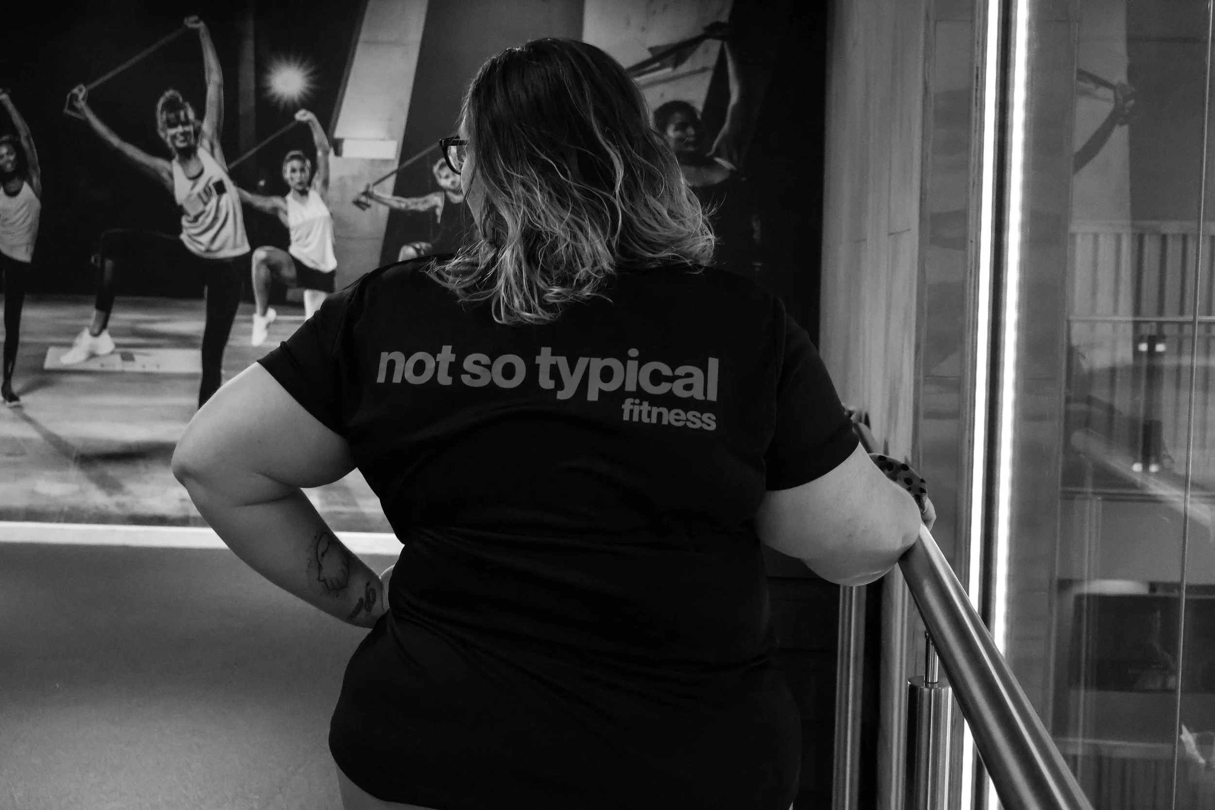 Rhiannon Cooper is a personal trainer and she is stood in the studio wearing a not so typical fitness shirt.